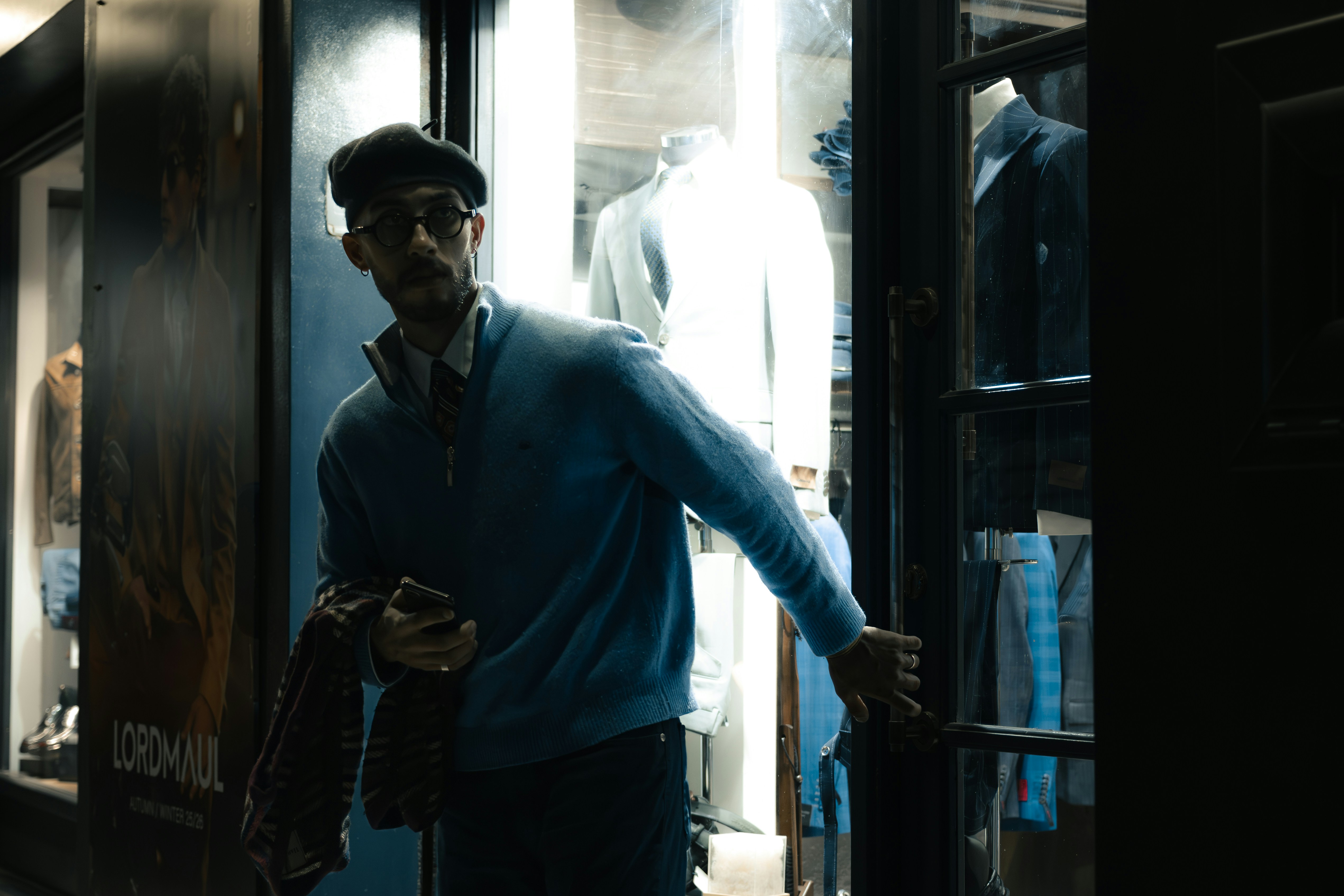 Man entering a brightly lit store at night