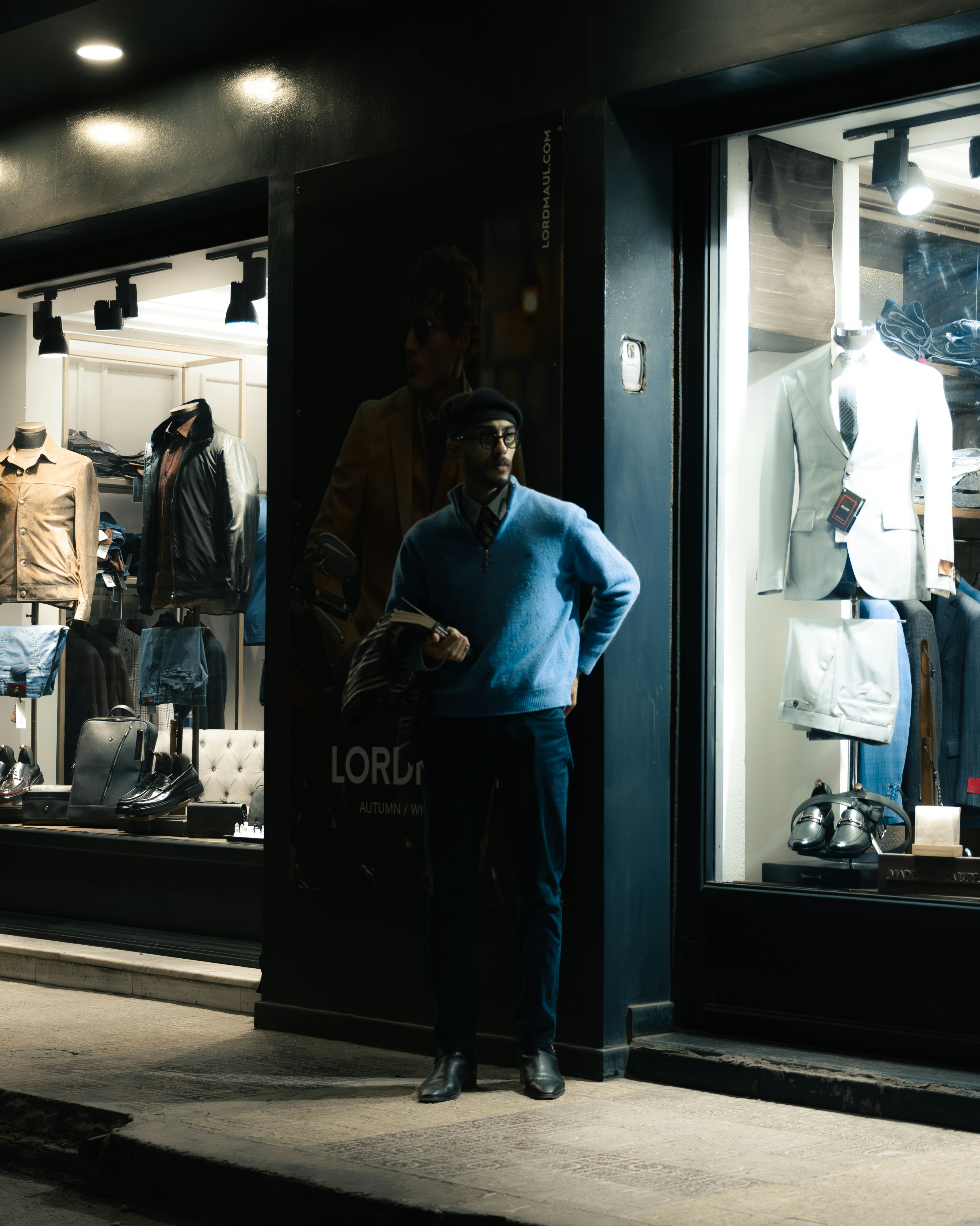 Man standing outside a clothing store at night. photo – Free Glasses ...