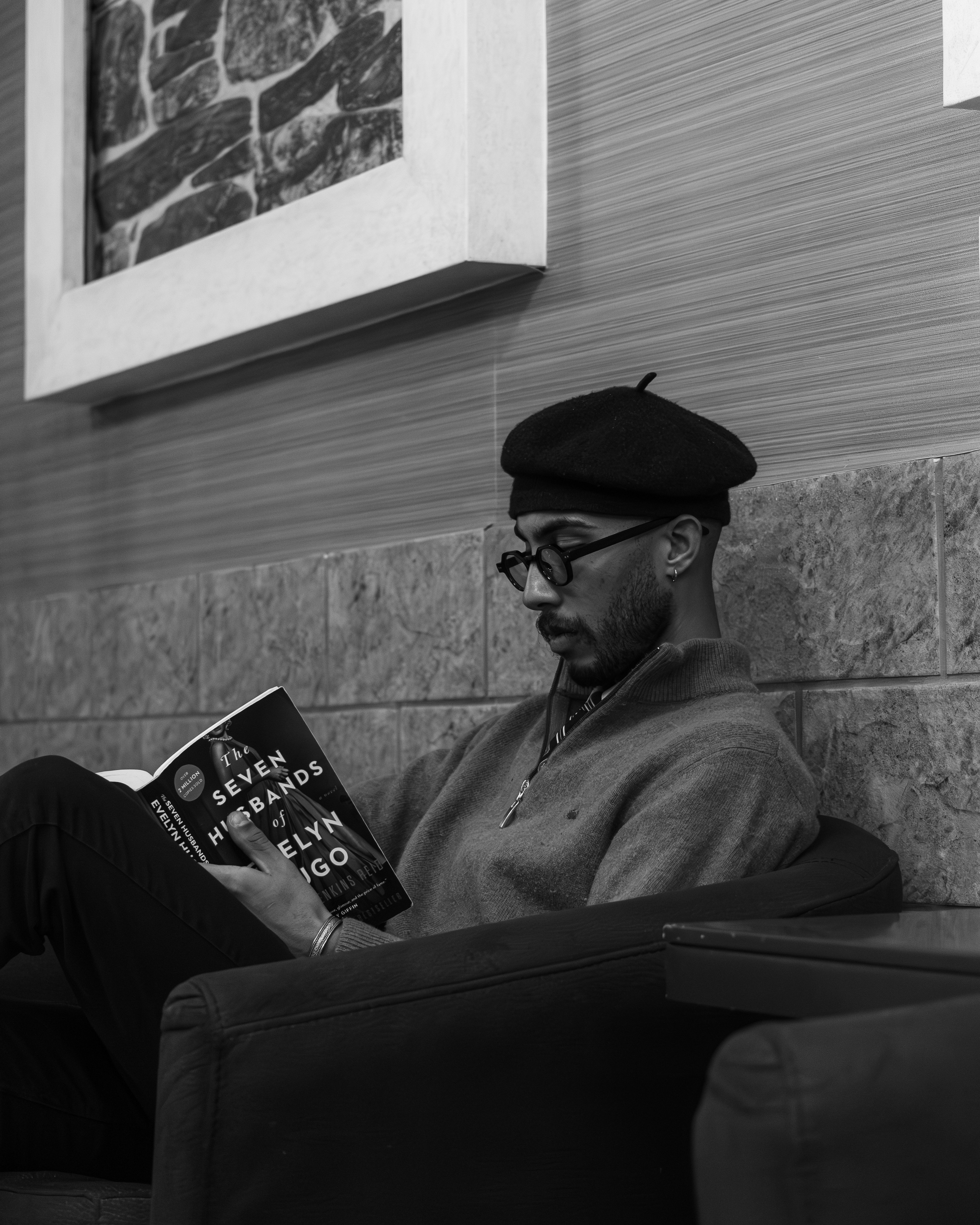 Man wearing beret reading a book indoors