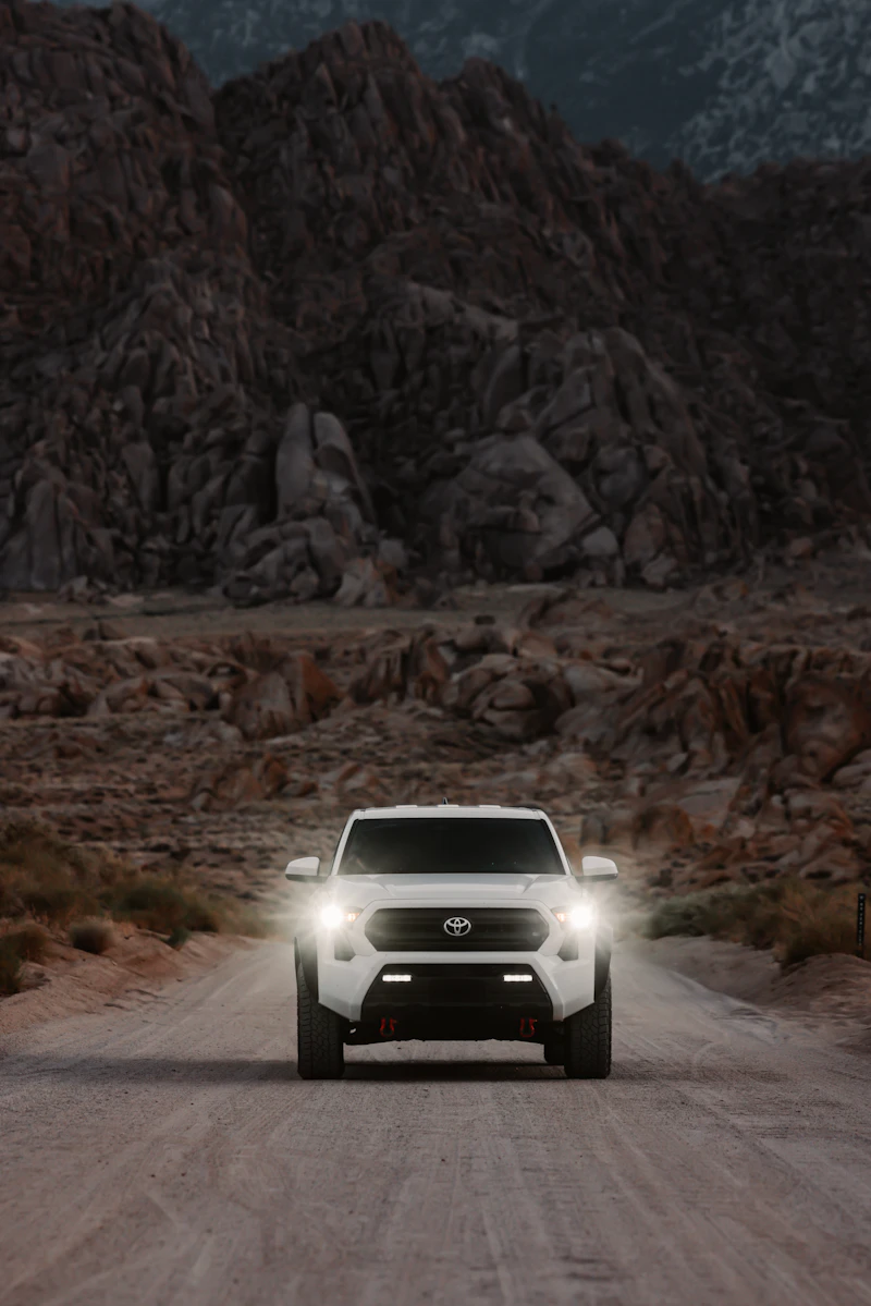 Truck on a dirt road beneath mountains