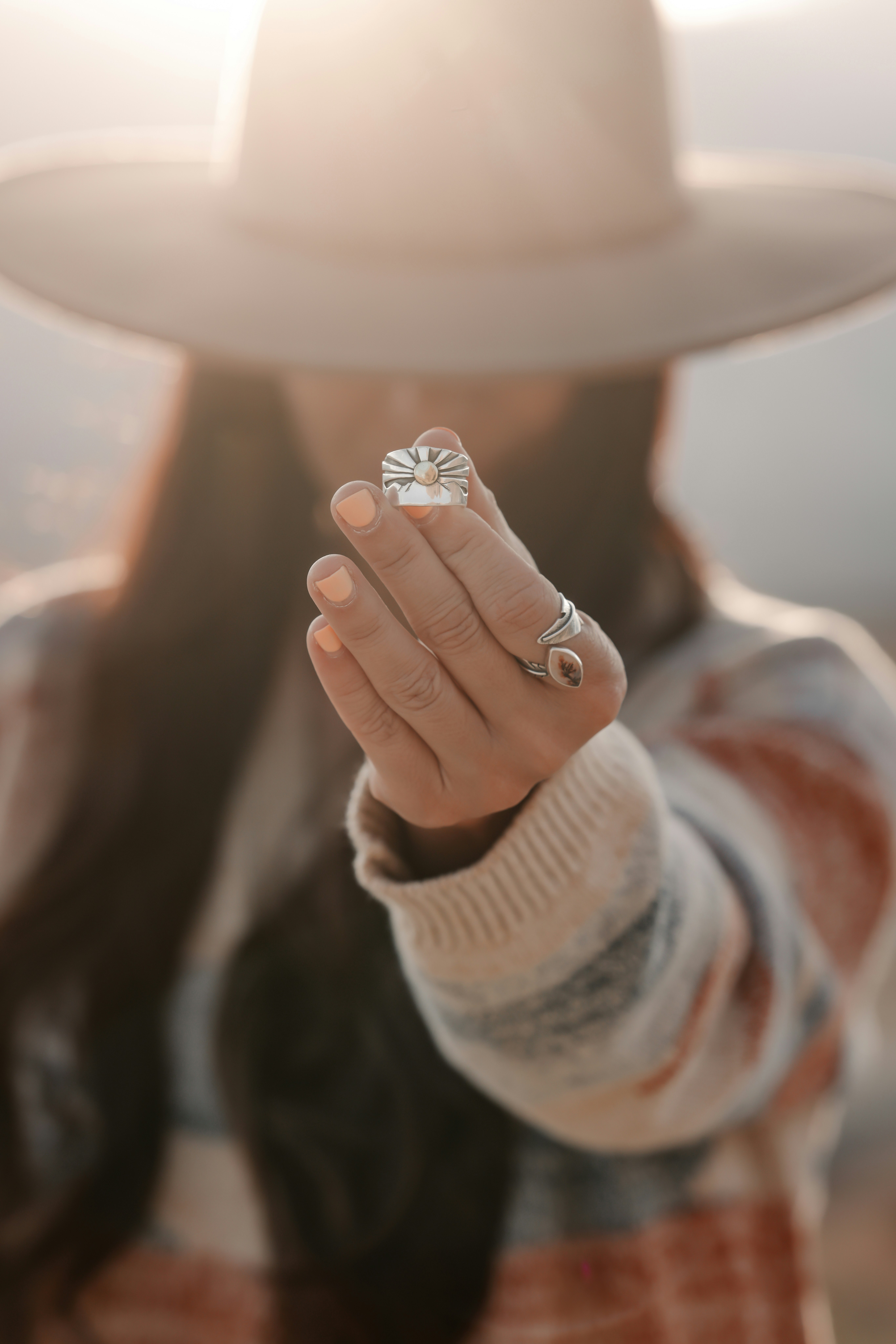 Woman in hat holds up a ring