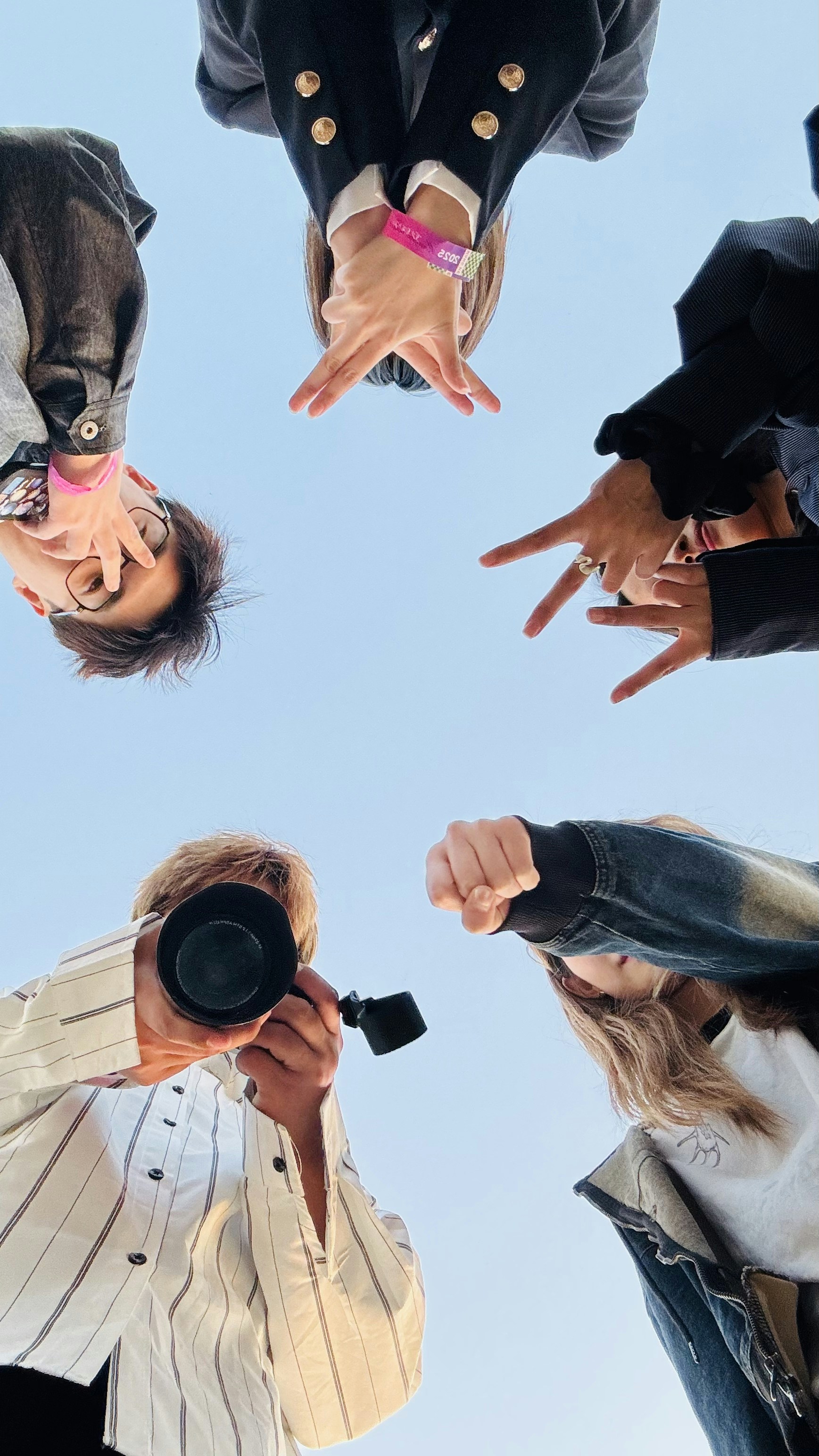 Gruppe von Menschen, die Gesten vor blauem Himmel machen