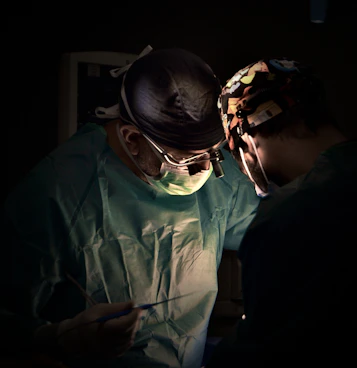 Surgeons performing a medical operation in a dark room.