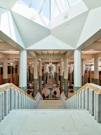 Grand interior with columns and staircase under skylight