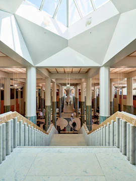 Grand interior with columns and staircase under skylight