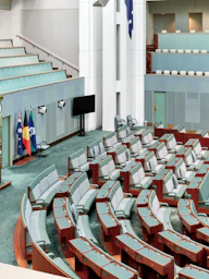 Empty parliamentary chamber with rows of seats