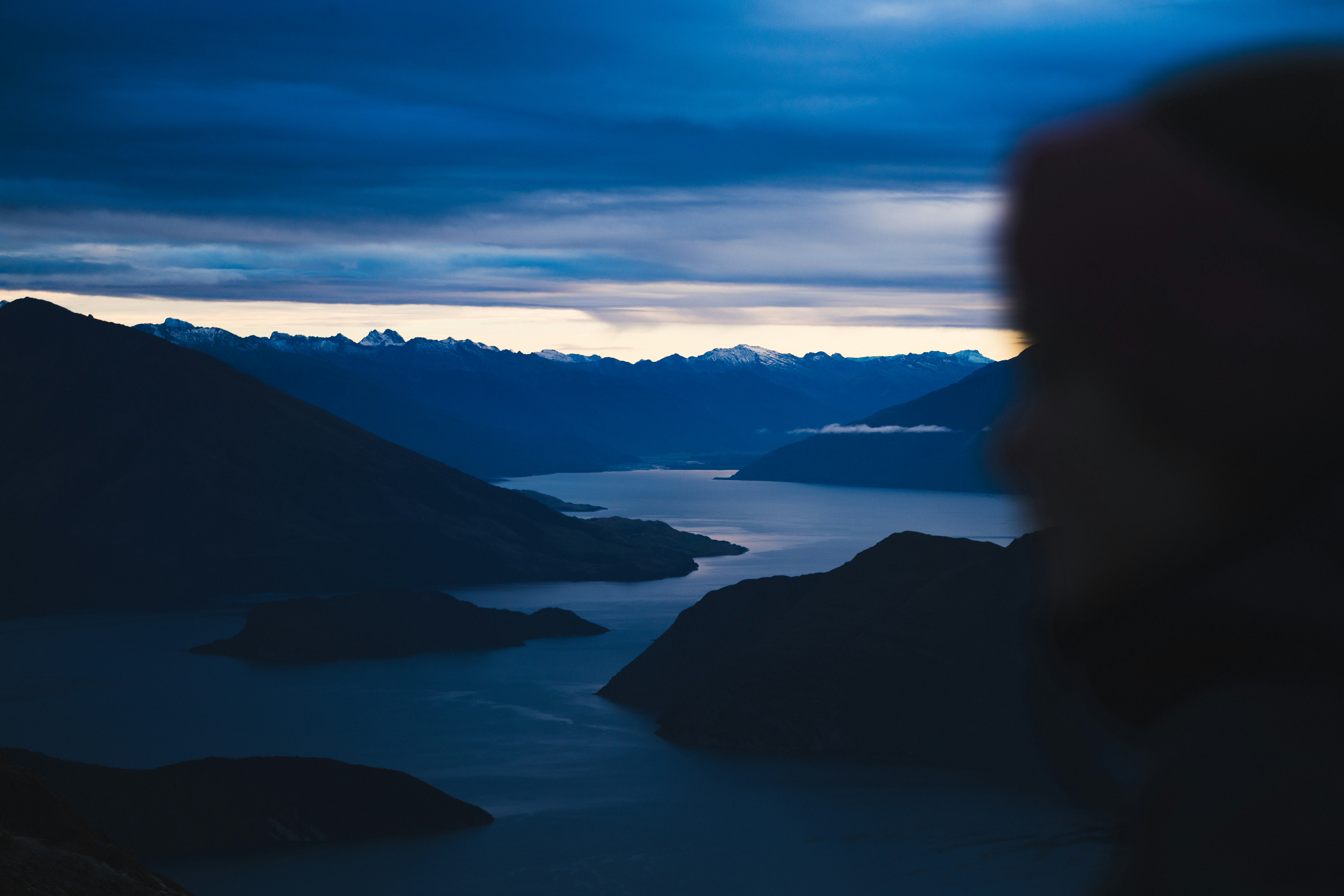 Dark mountains overlook a calm lake at dusk