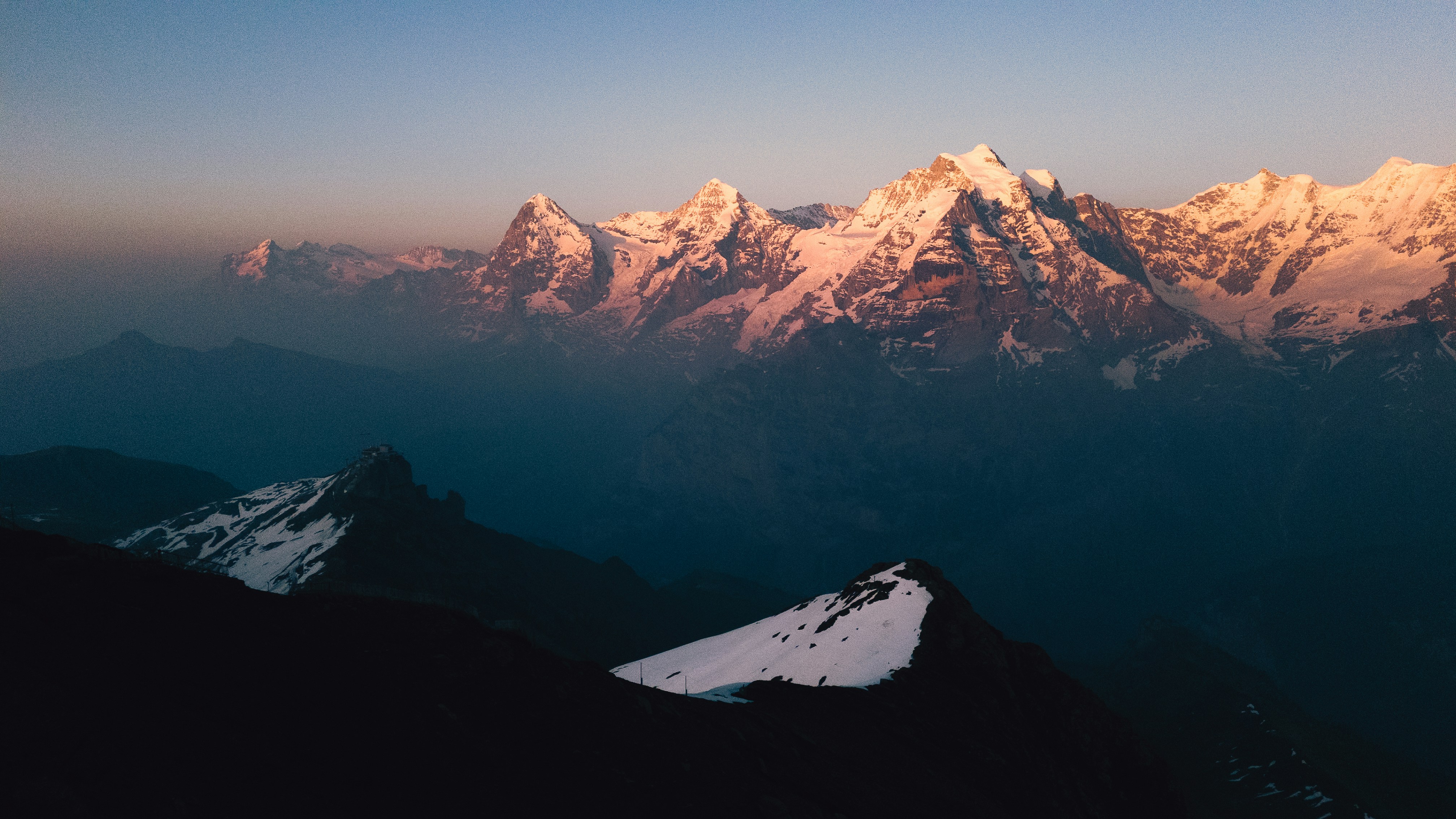 Snow-capped mountains bathed in golden sunset light