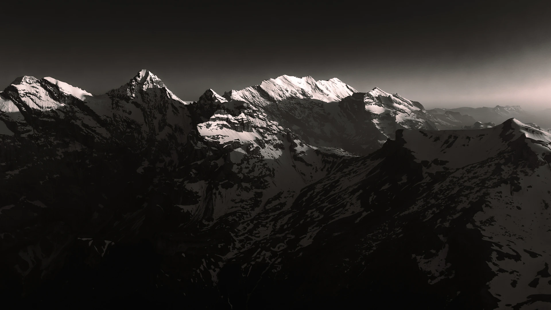 Majestic snow-capped mountains under a dramatic sky.