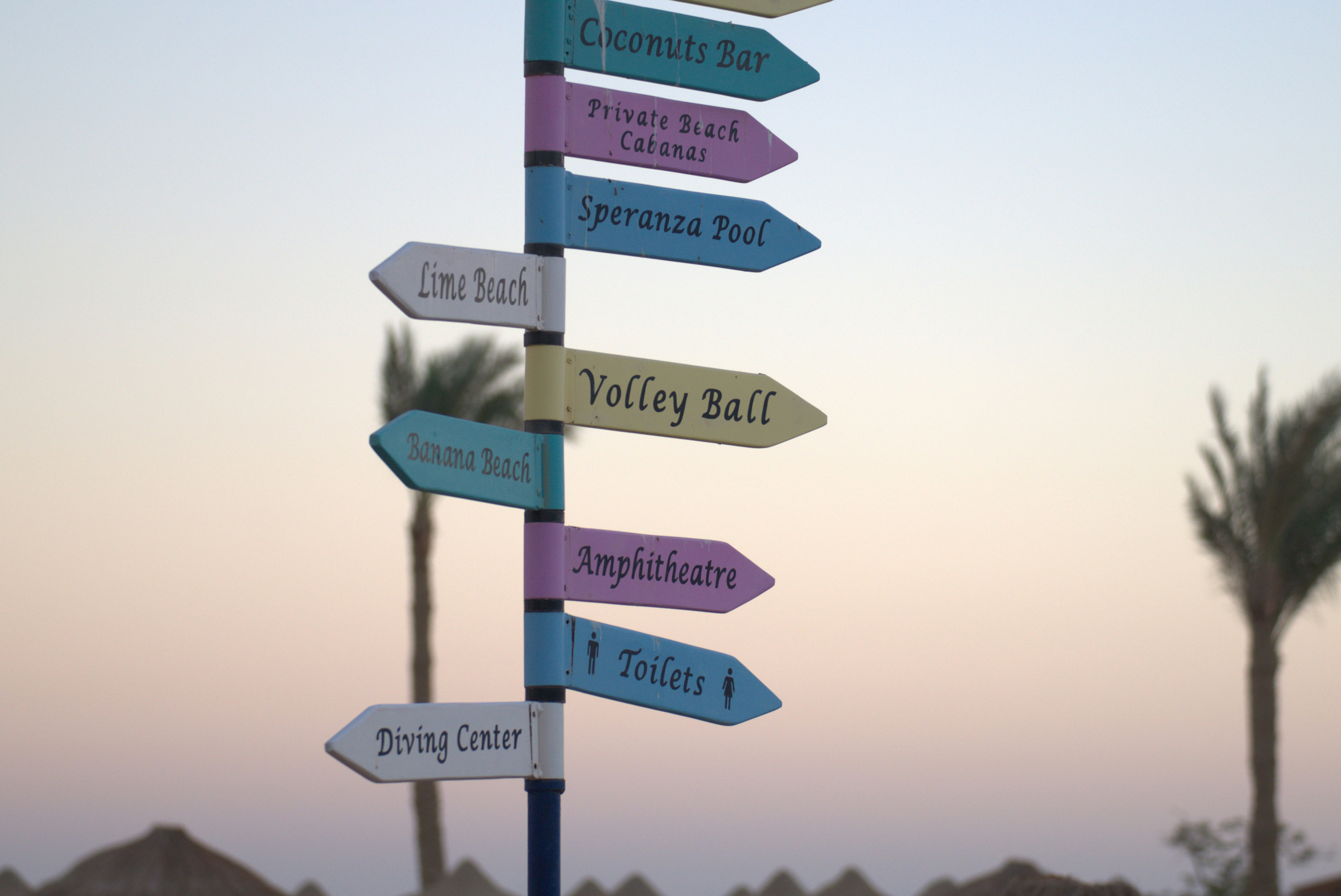 Directional signs at a beach resort at sunset