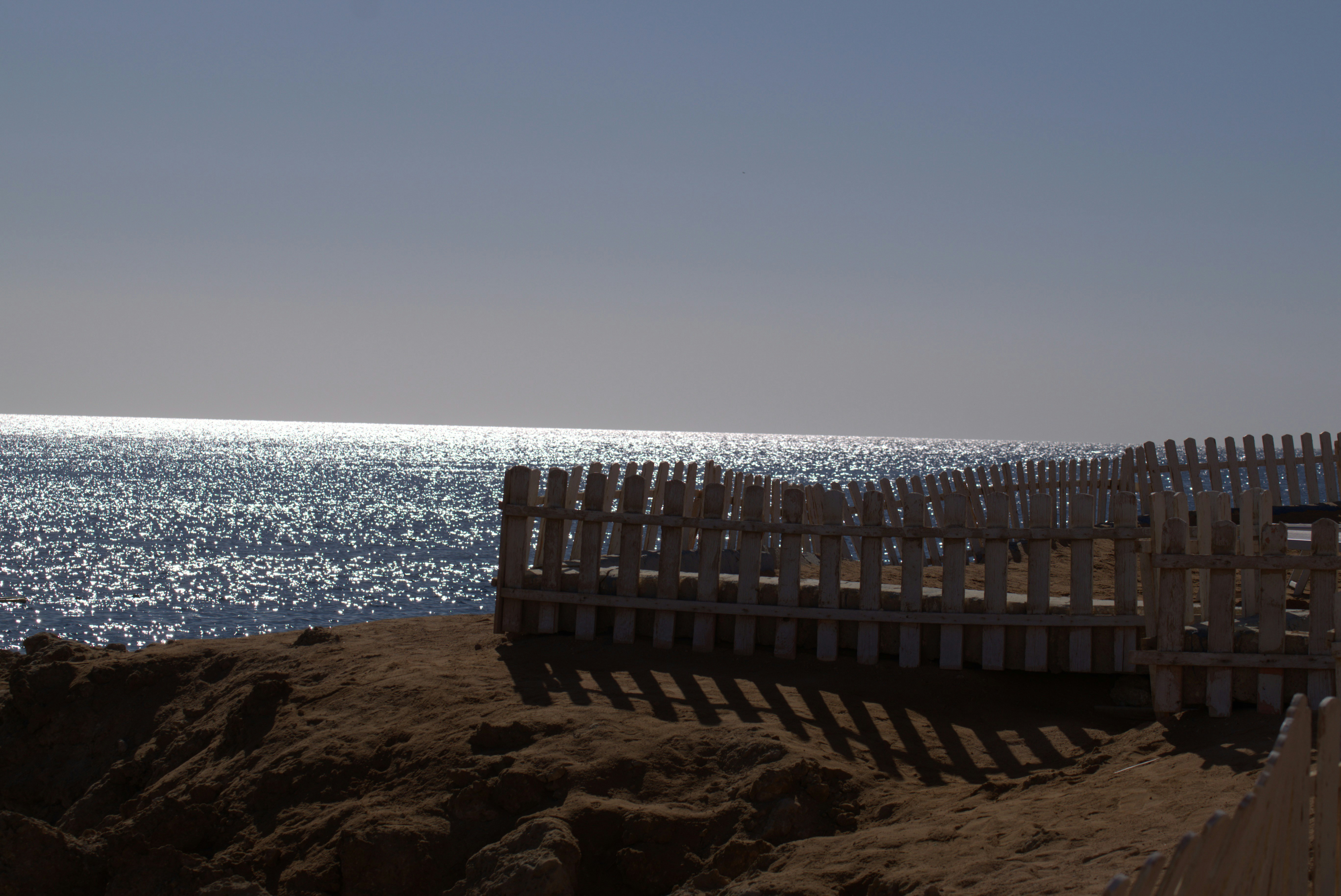 Sparkling ocean water with a white fence