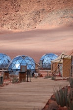 Geodesic domes and tents in a desert landscape.