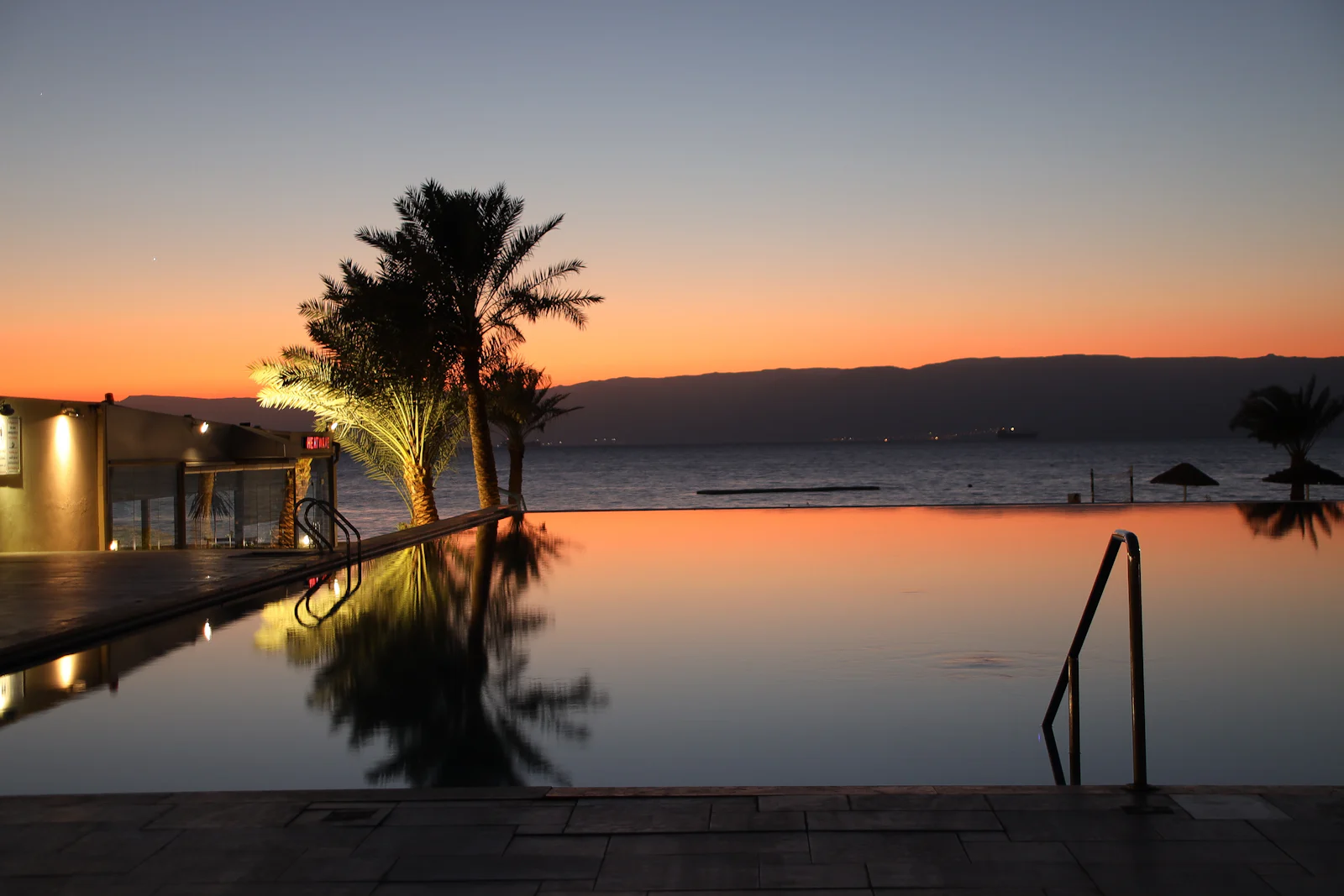 Piscina infinita al atardecer sobre el océano