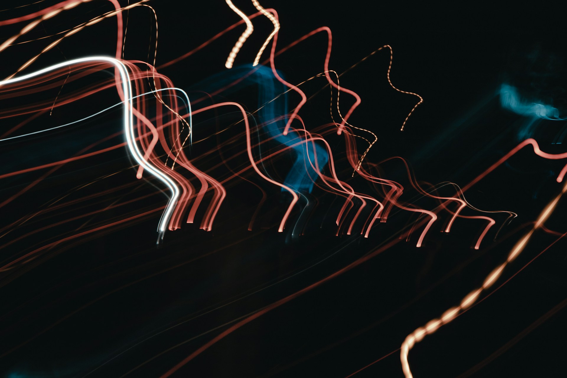 Abstract streaks of red and white light on black.