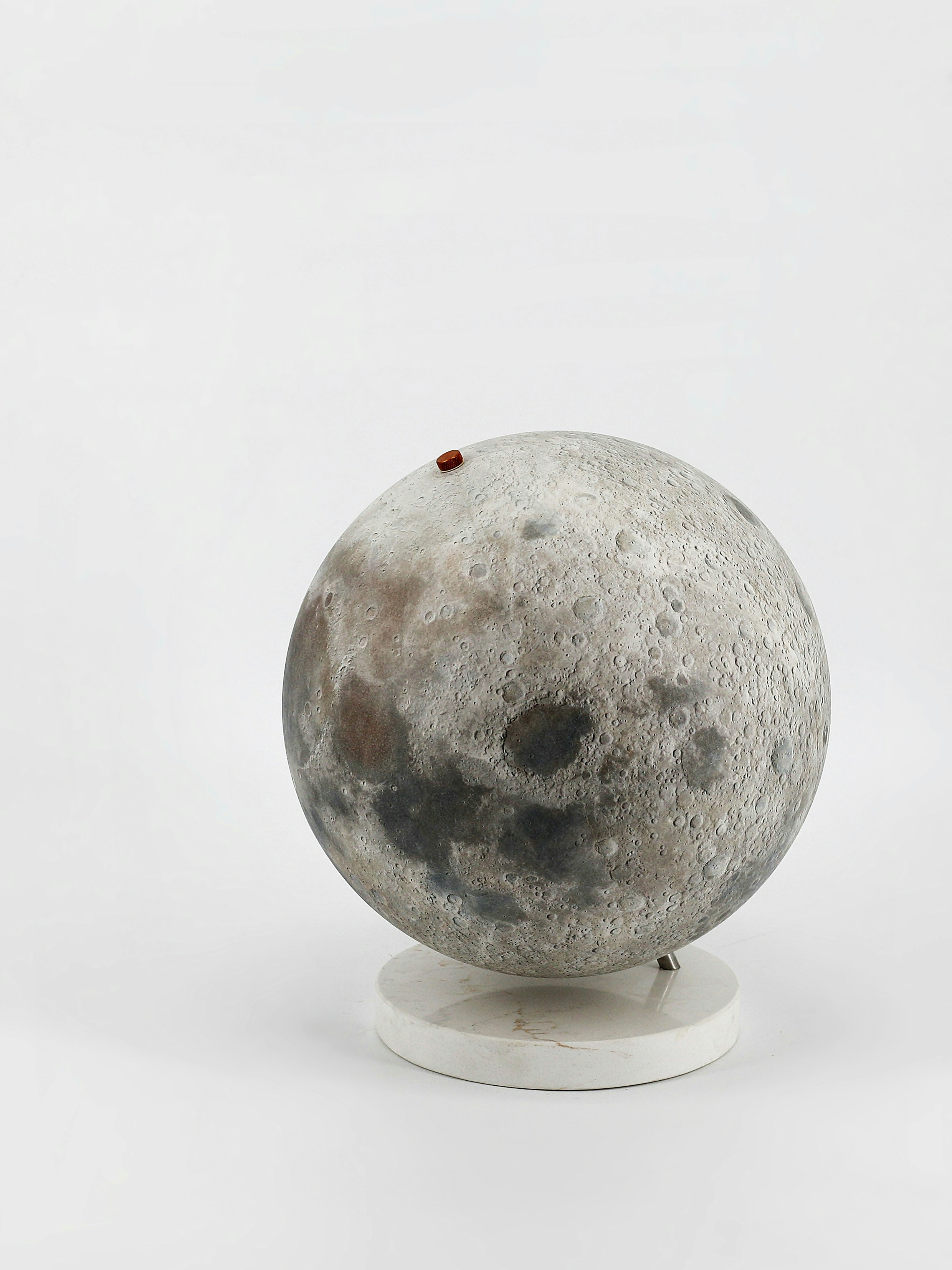 A model of the moon on a white stand.