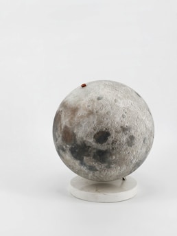 A model of the moon on a white stand.
