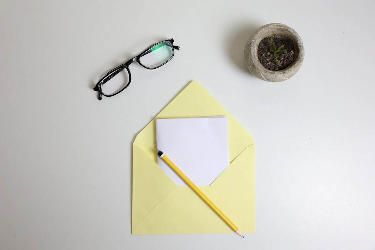 Reading glasses and a pencil resting on a paper envelope