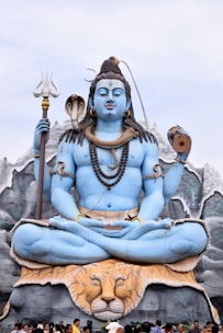 A large blue statue of lord shiva meditating
