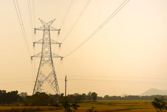 Tall metal pylon with power lines against hazy sky