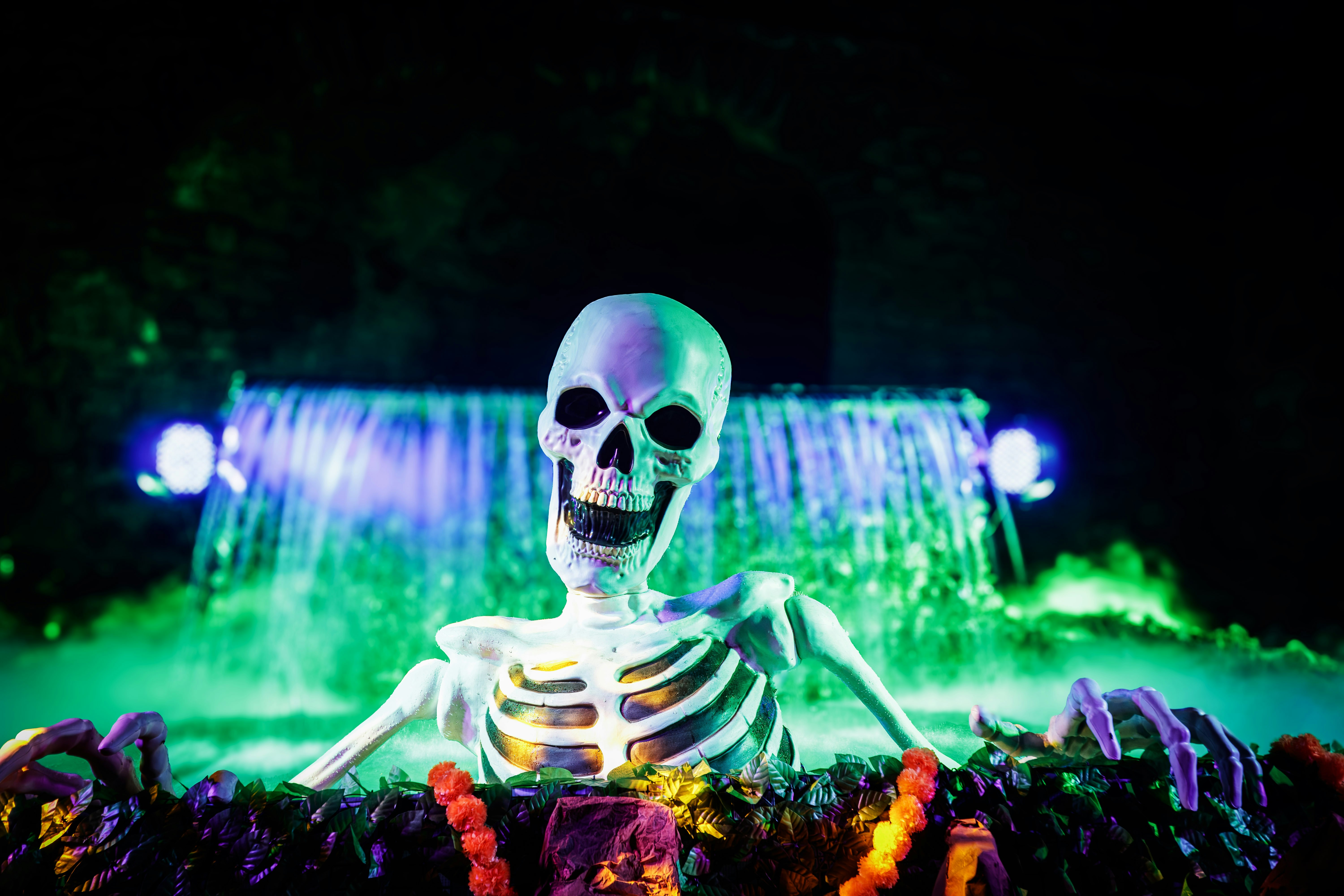 Skeleton emerging from murky green water with waterfall