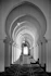 Man walks down long arched hallway of mosque