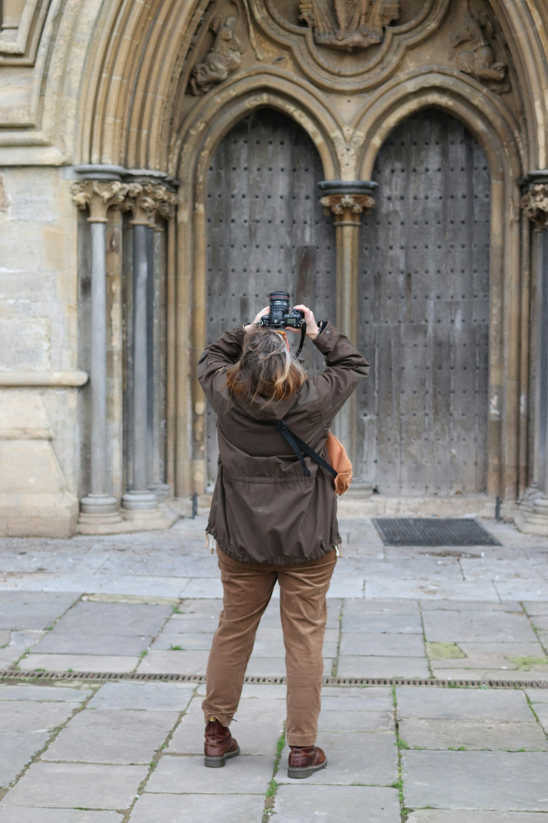 Person taking a picture of a large wooden door - history photo walks