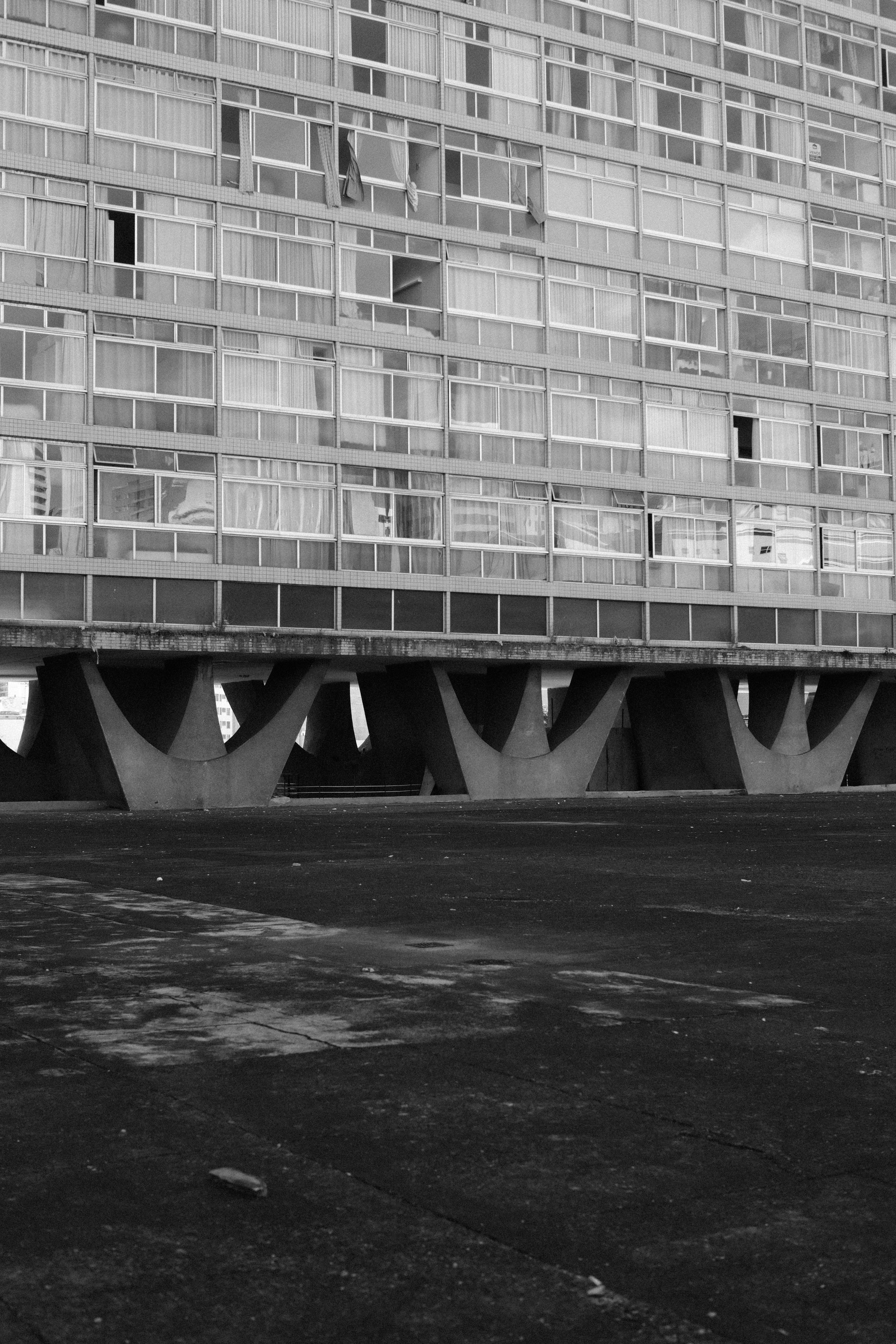 多くの窓とコンクリートの支柱を備えたモダニズムの建物