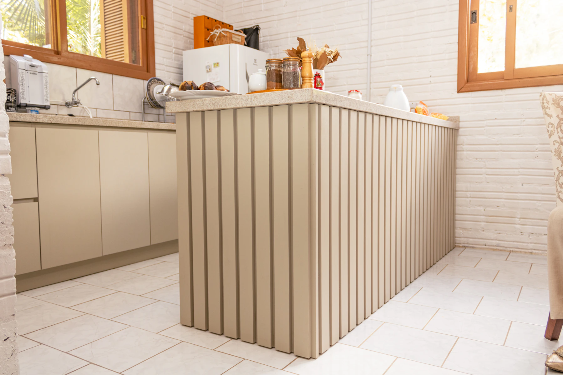 Modern kitchen island with vertical paneling and a restrained surrounding cabinet composition