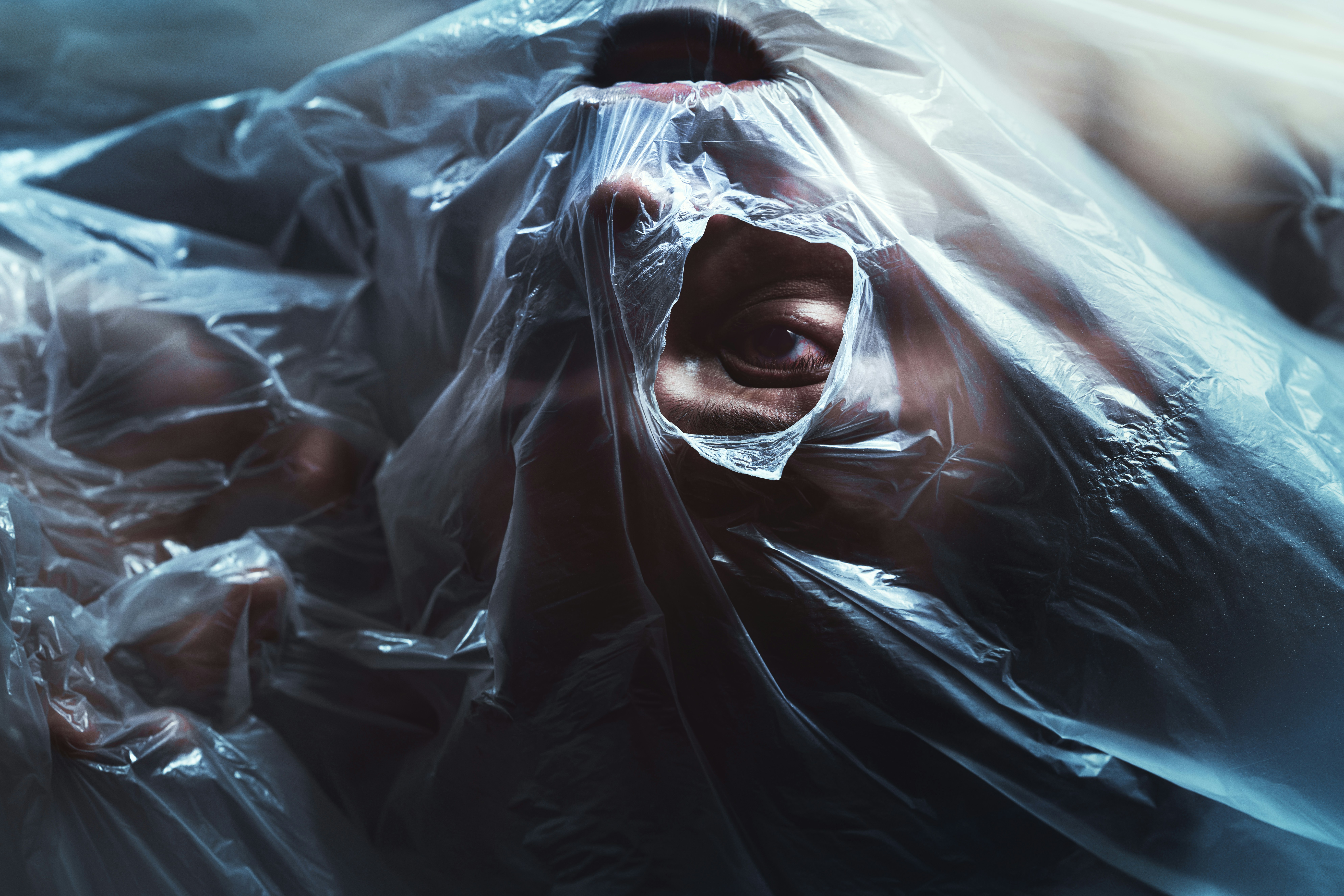 Person, die sich in Plastikfolie abmüht