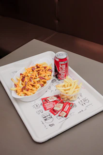 Fries with sausage, cheese, and a soda
