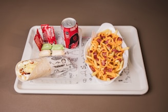 Burrito, cheese fries, and soda on a tray