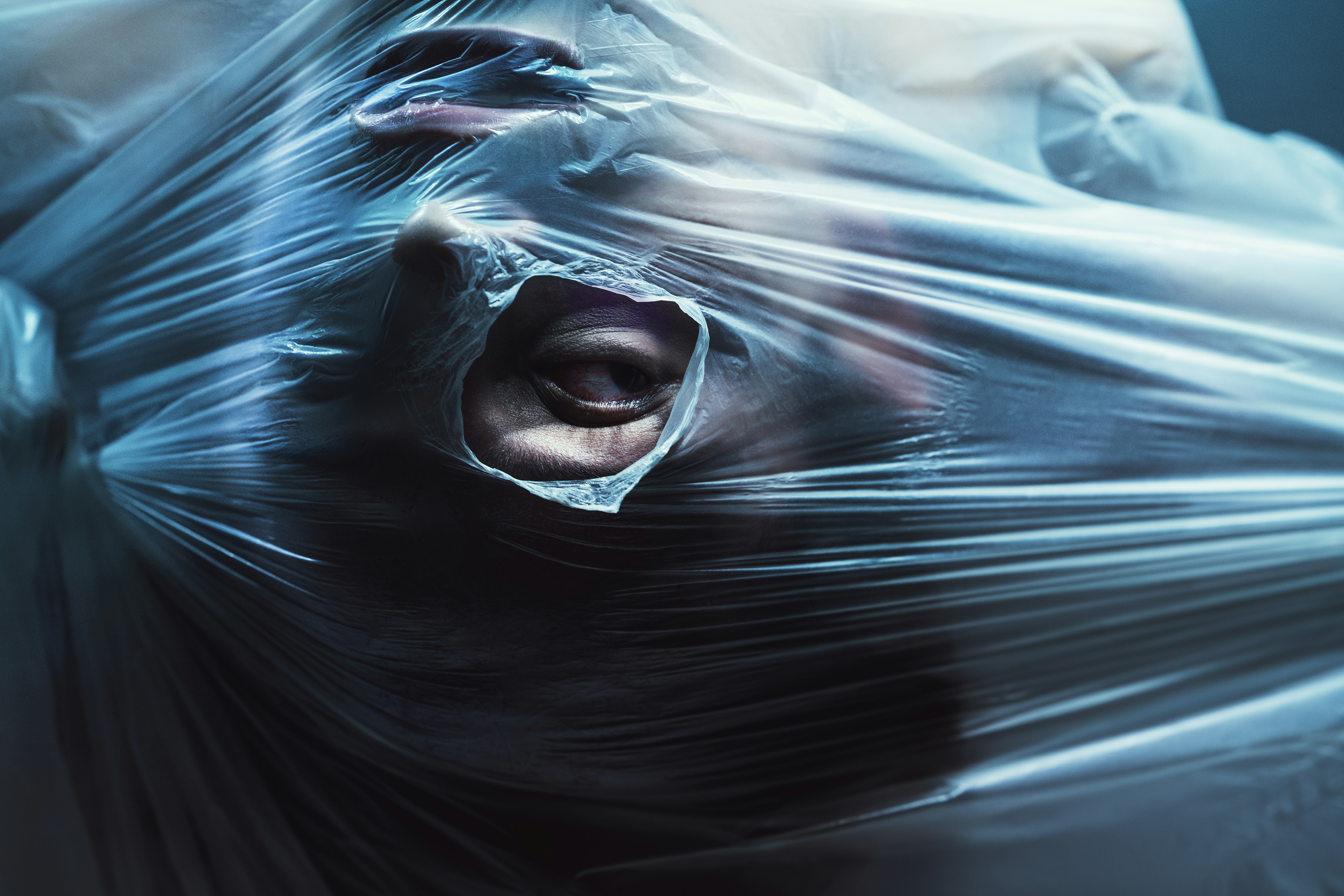 Person struggling inside plastic wrap