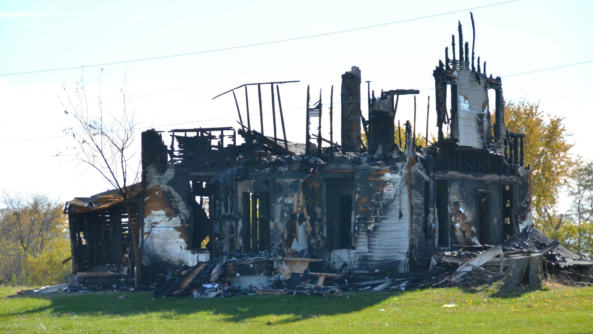 A house destroyed by fire, with only charred framing left standing