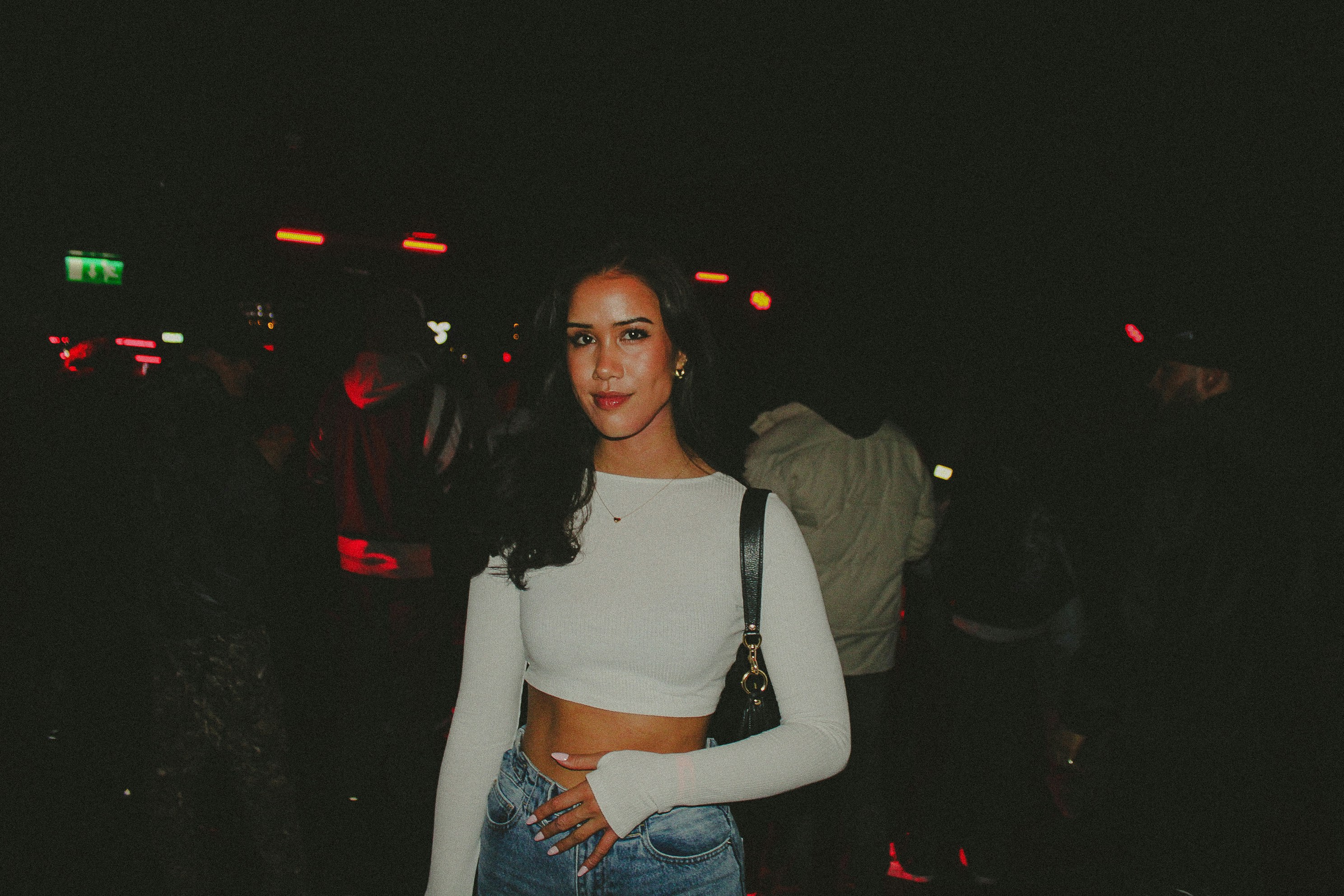 Woman in a white top and jeans at night