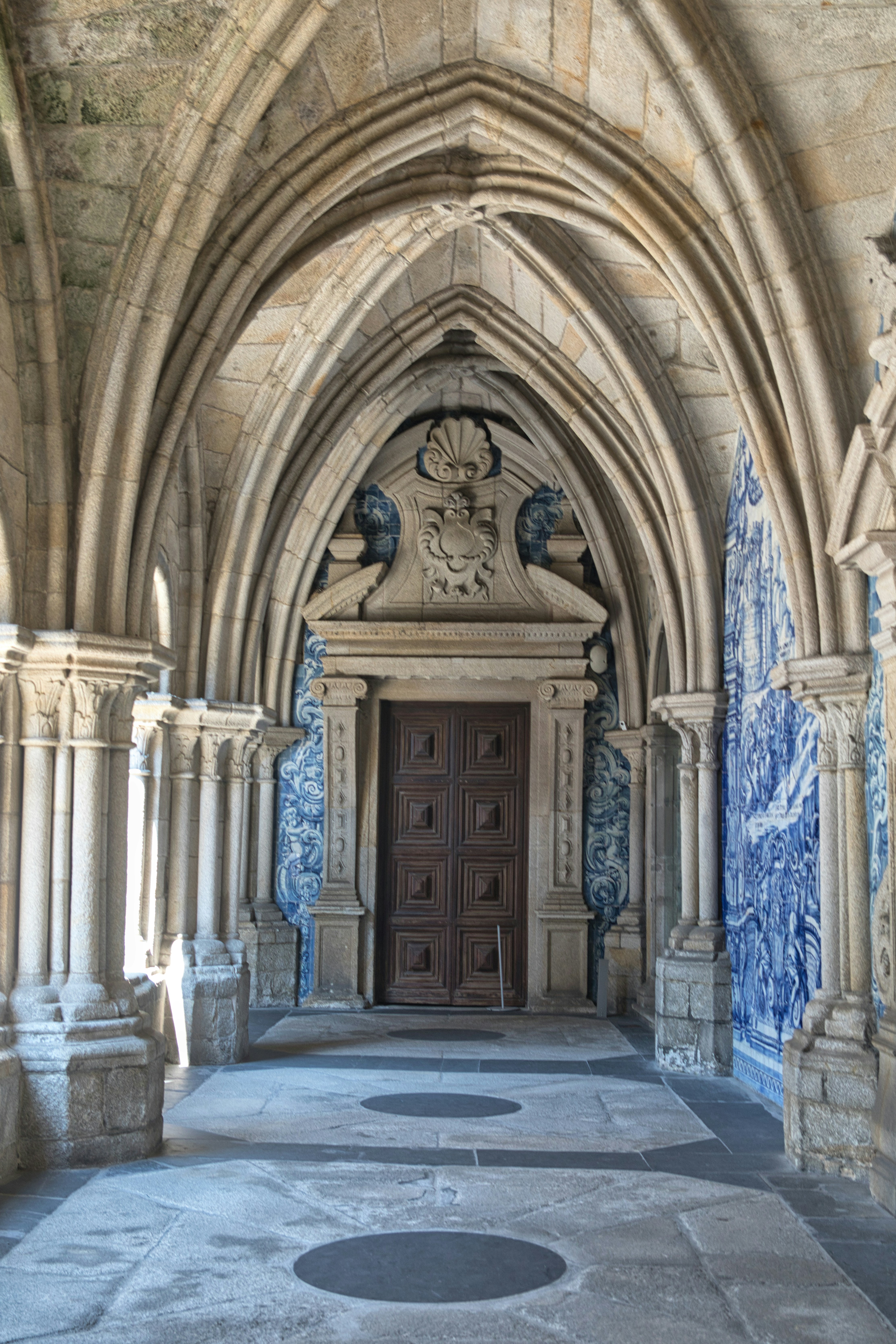 Arched walkway with ornate doorway and blue tile walls