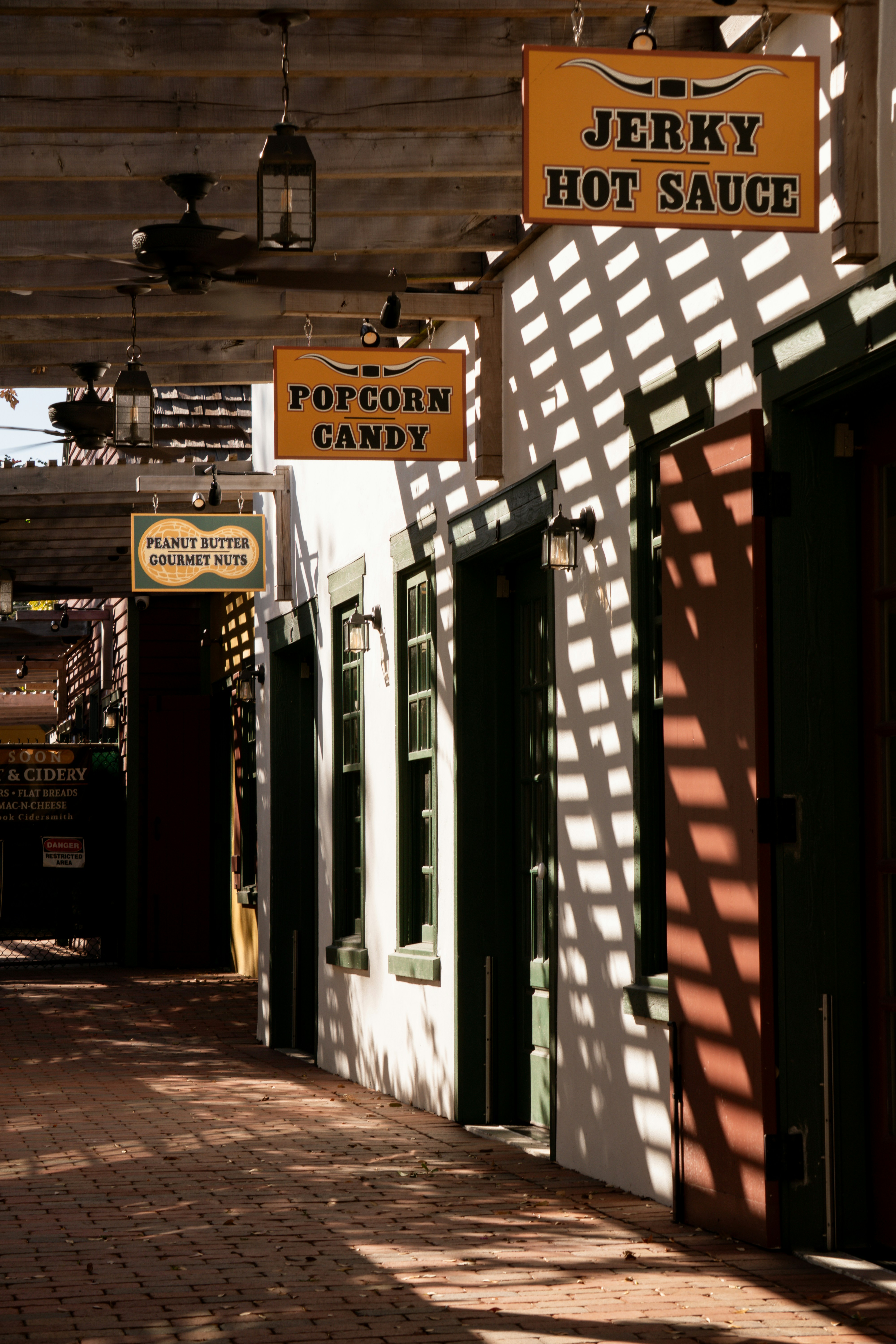 Shaded walkway with signs for jerky, popcorn, and candy