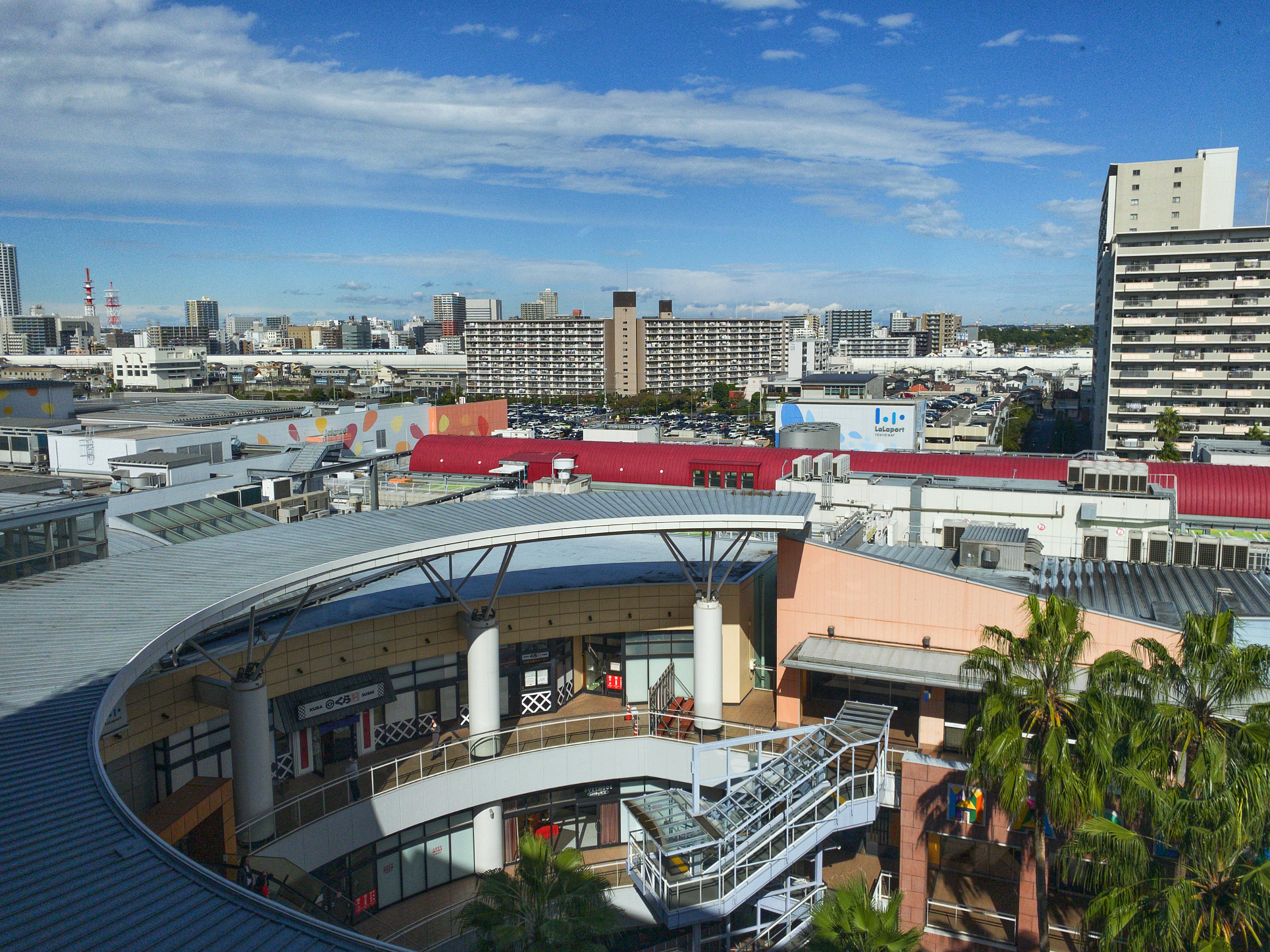 Modern shopping mall with surrounding urban buildings.
