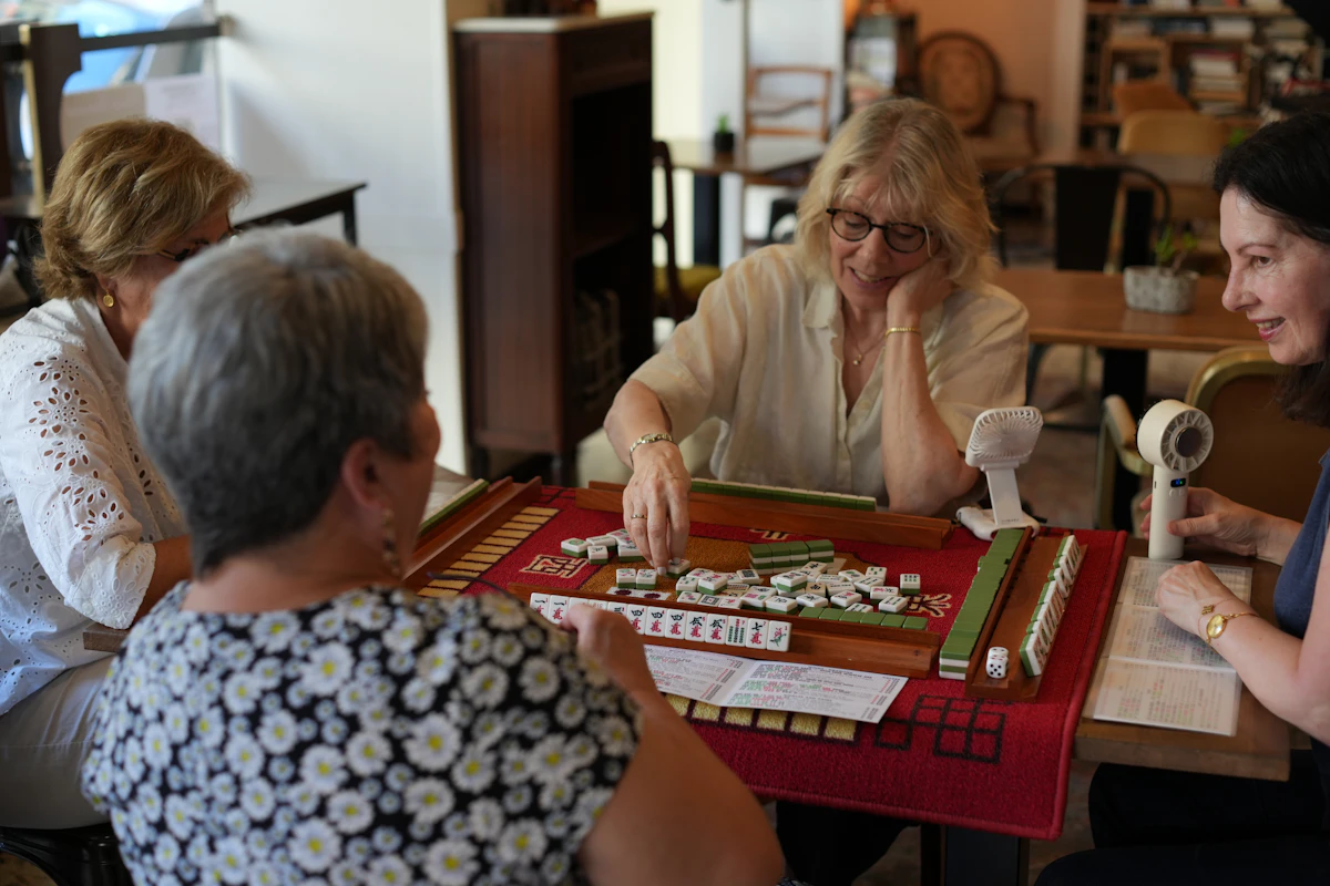 Four women playing a game of mahjong at a table