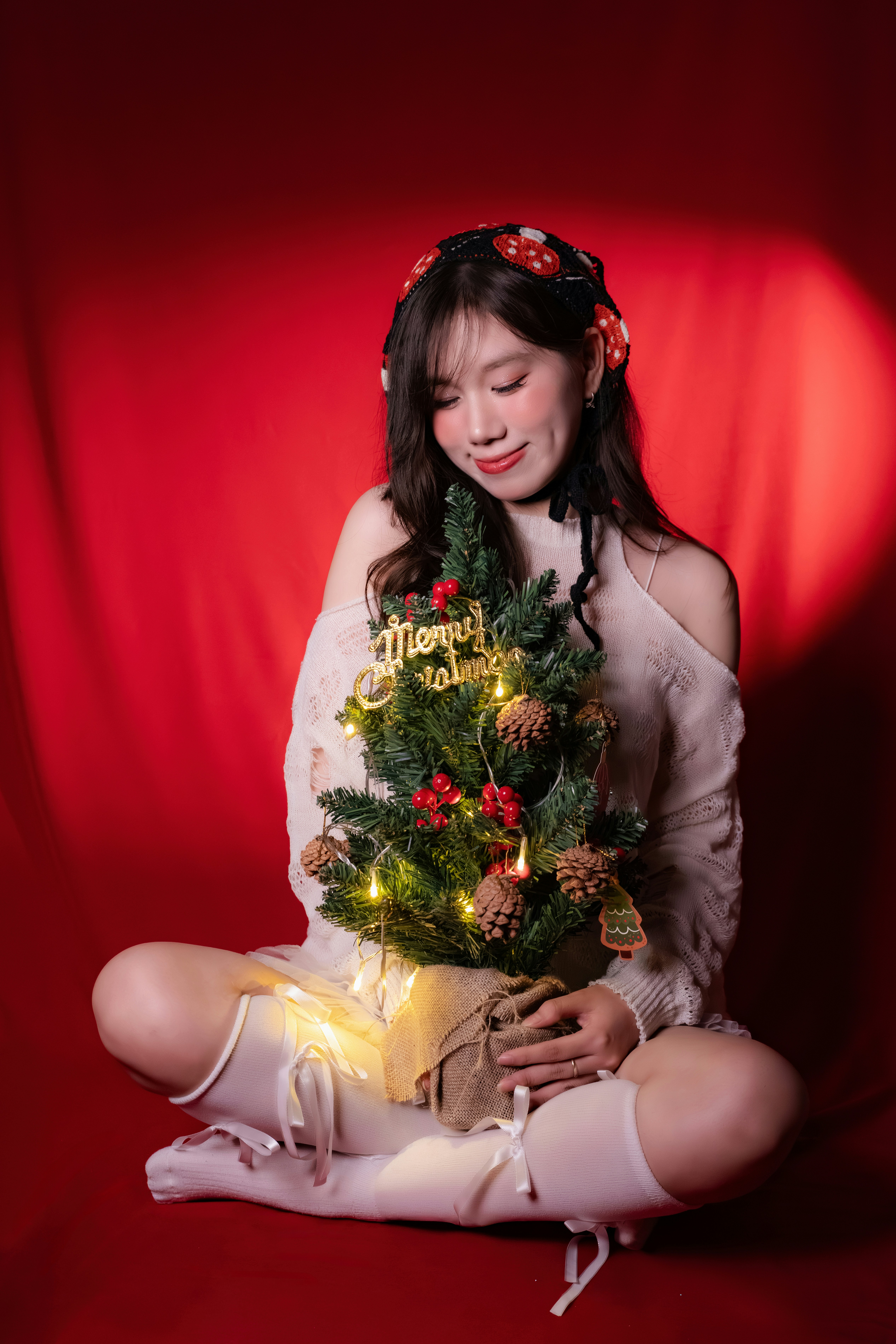 Woman holding a small decorated christmas tree