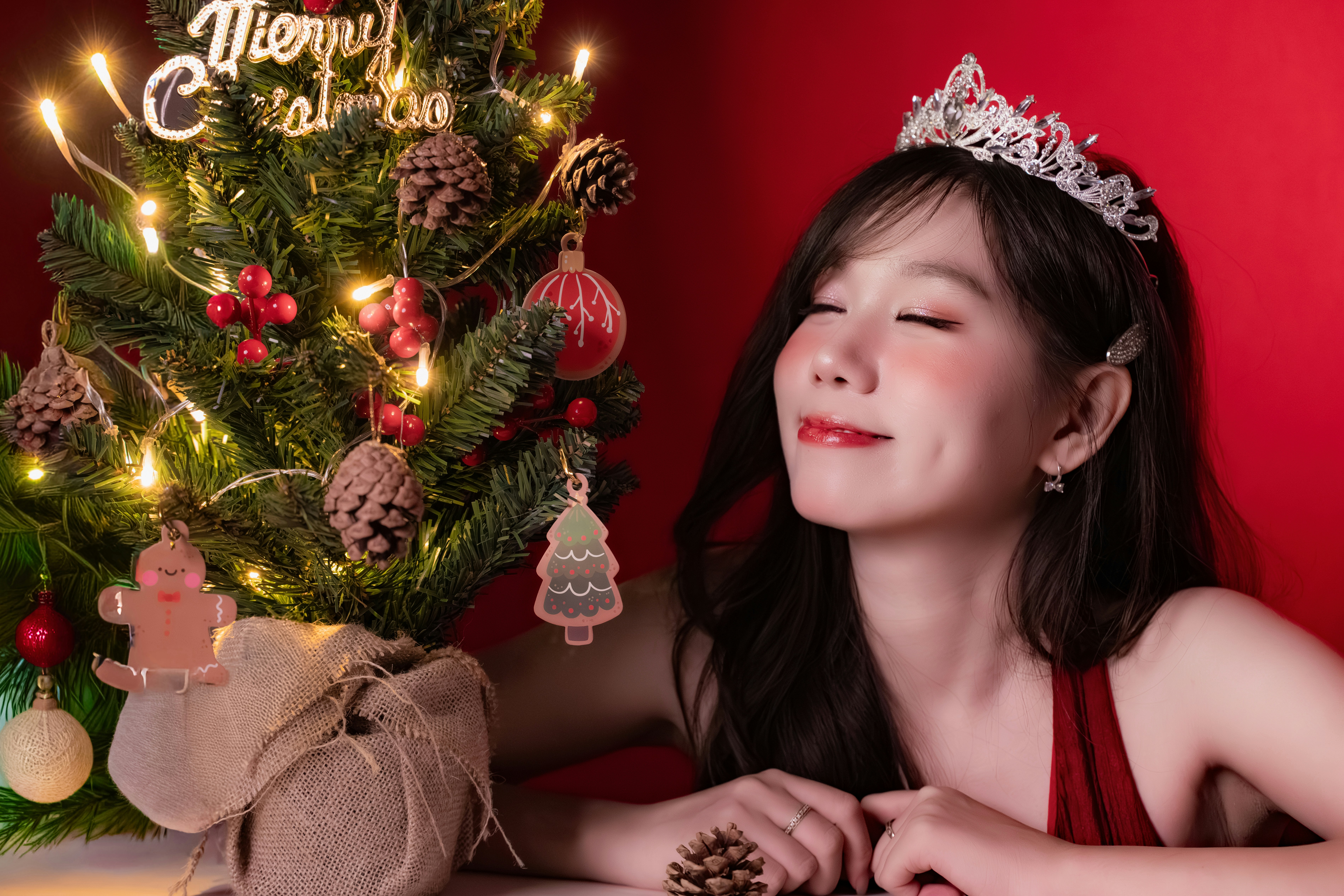 Woman in tiara by decorated christmas tree