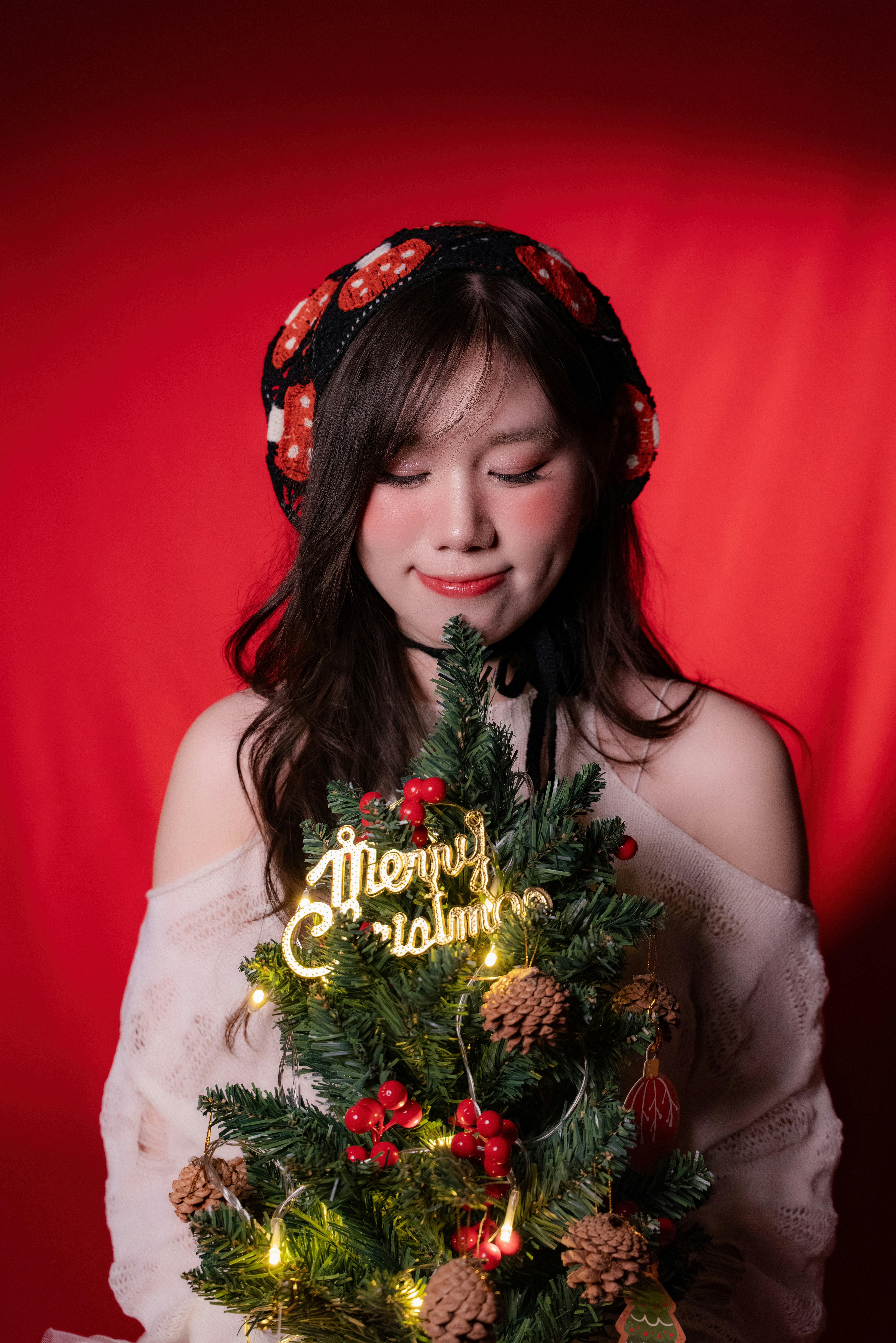 Woman holding a small decorated christmas tree