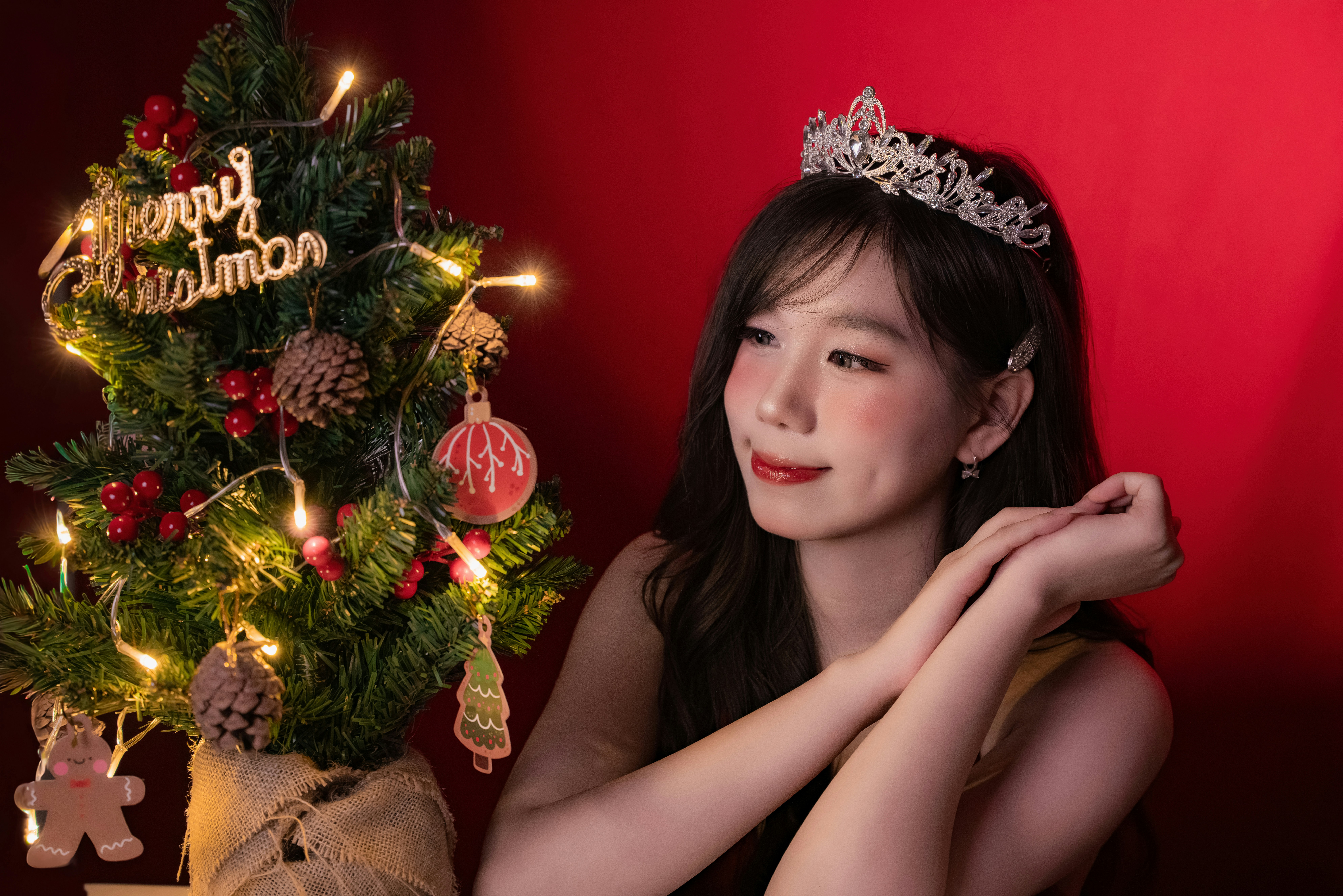 Woman wearing a tiara by a christmas tree