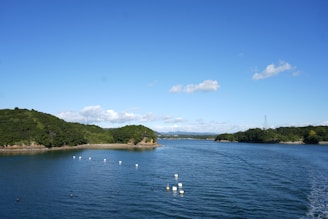 Calm blue water with green islands under a clear sky.