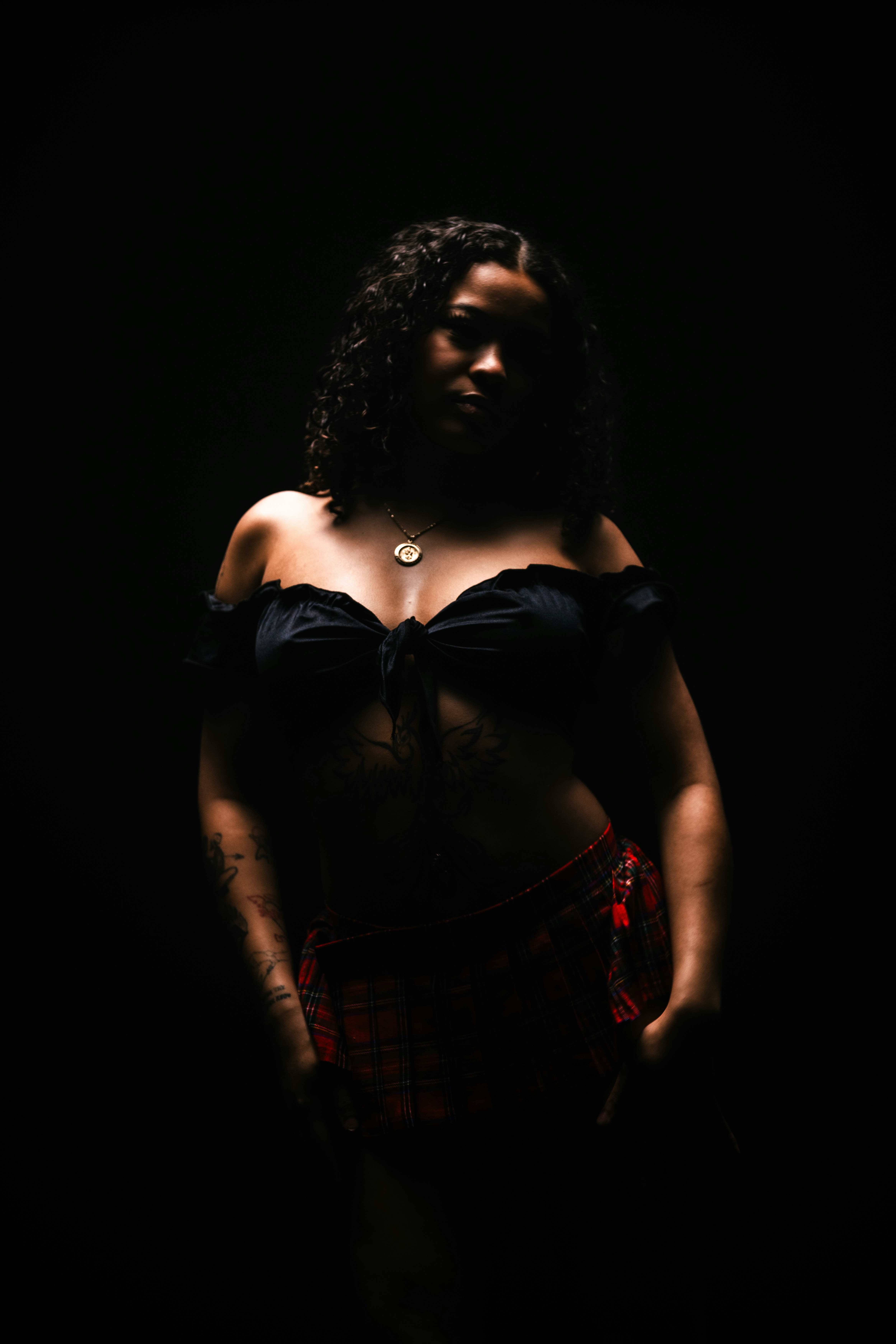 Woman in off-the-shoulder top and plaid skirt