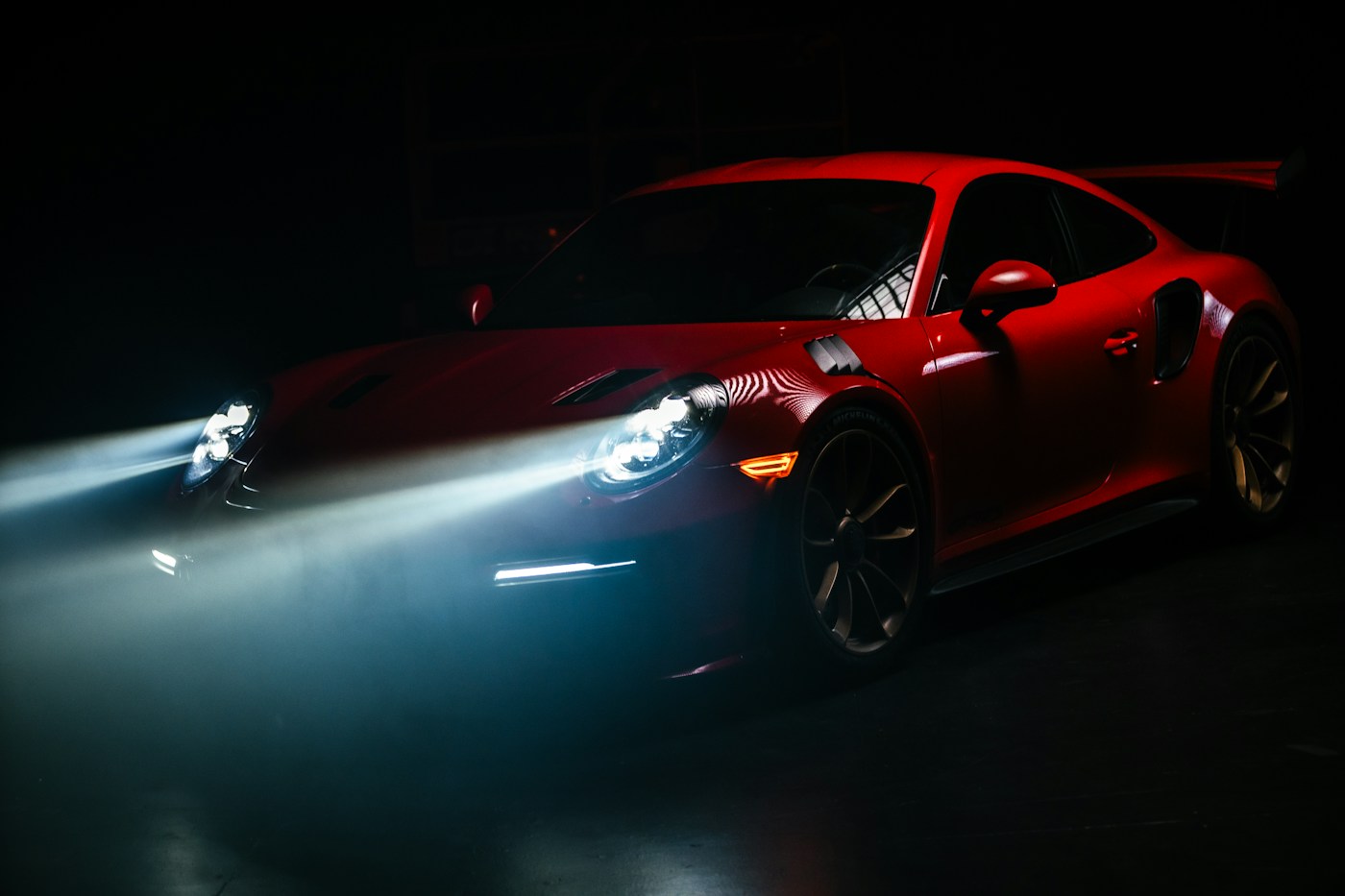 Glossy red sports car headlight in close-up