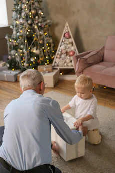 Grandfather and child opening a christmas gift.
