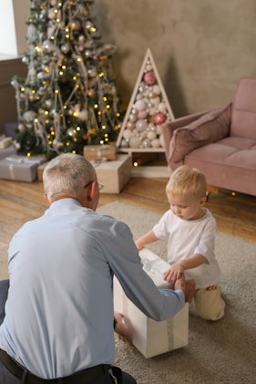 Grandfather and child opening a christmas gift.