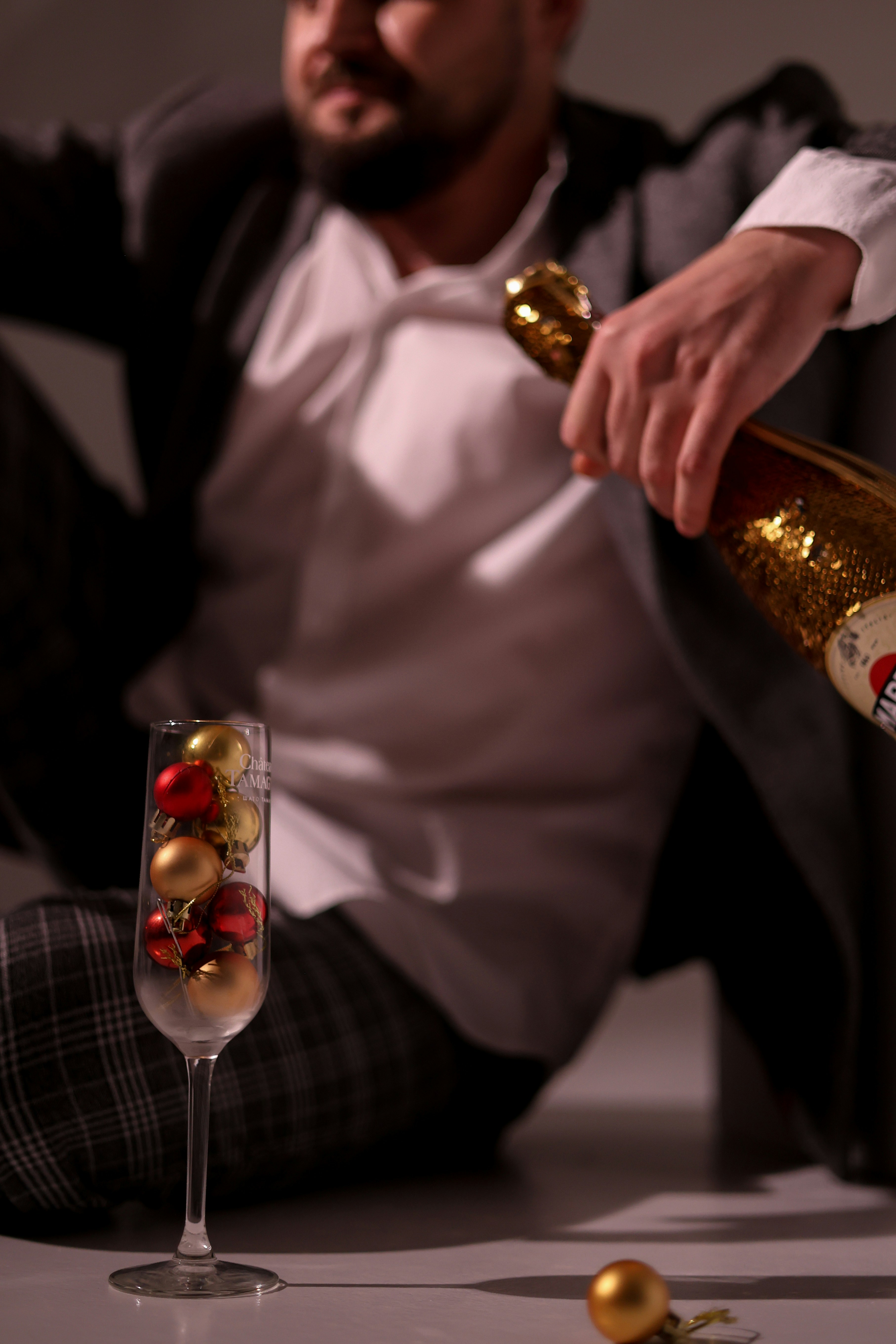 Man pouring champagne into a glass with ornaments