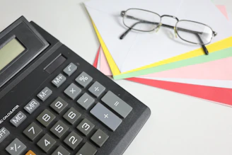 Calculator and glasses on colorful papers