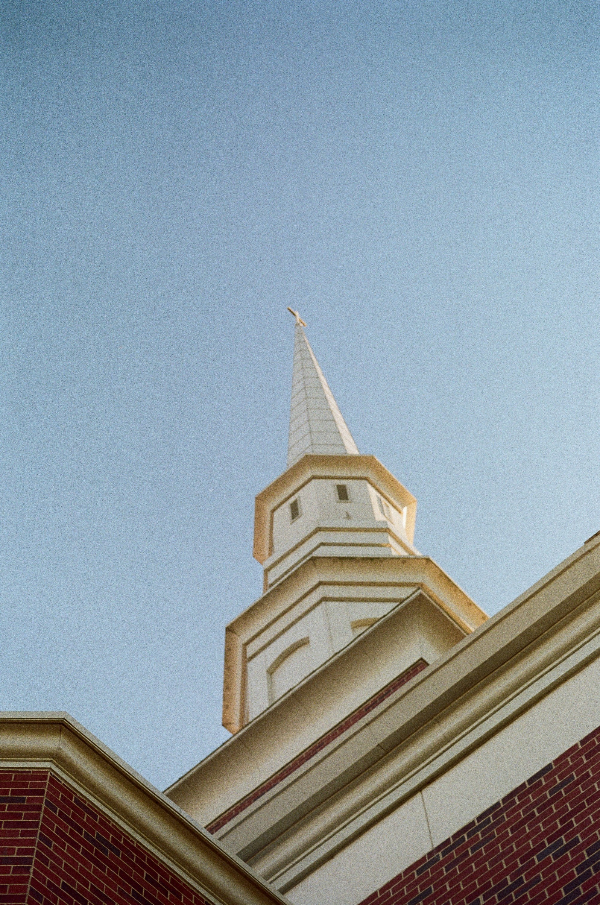White steeple of a building against a clear blue sky